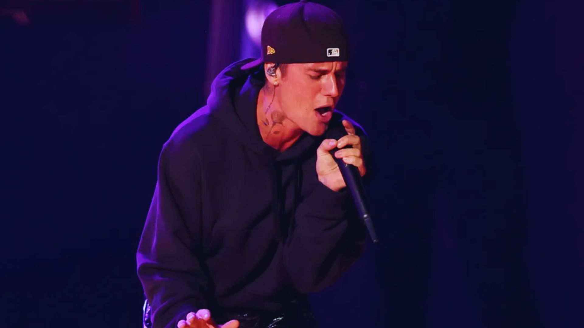 Justin Bieber performing on stage at the 2016 MTV Music Awards, surrounded by vibrant lights and an enthusiastic audience.