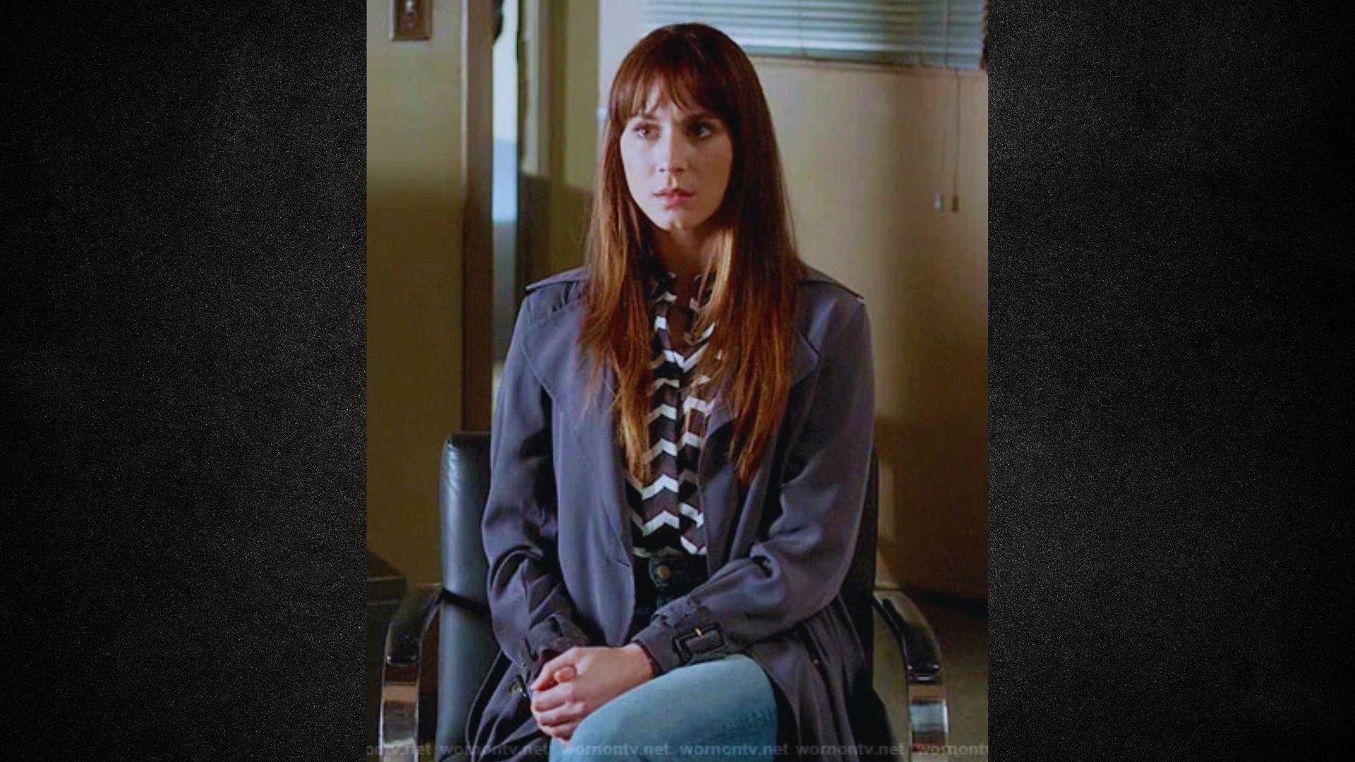 A girl is sitting in a chair, looking thoughtfully to the side in a cozy indoor setting.