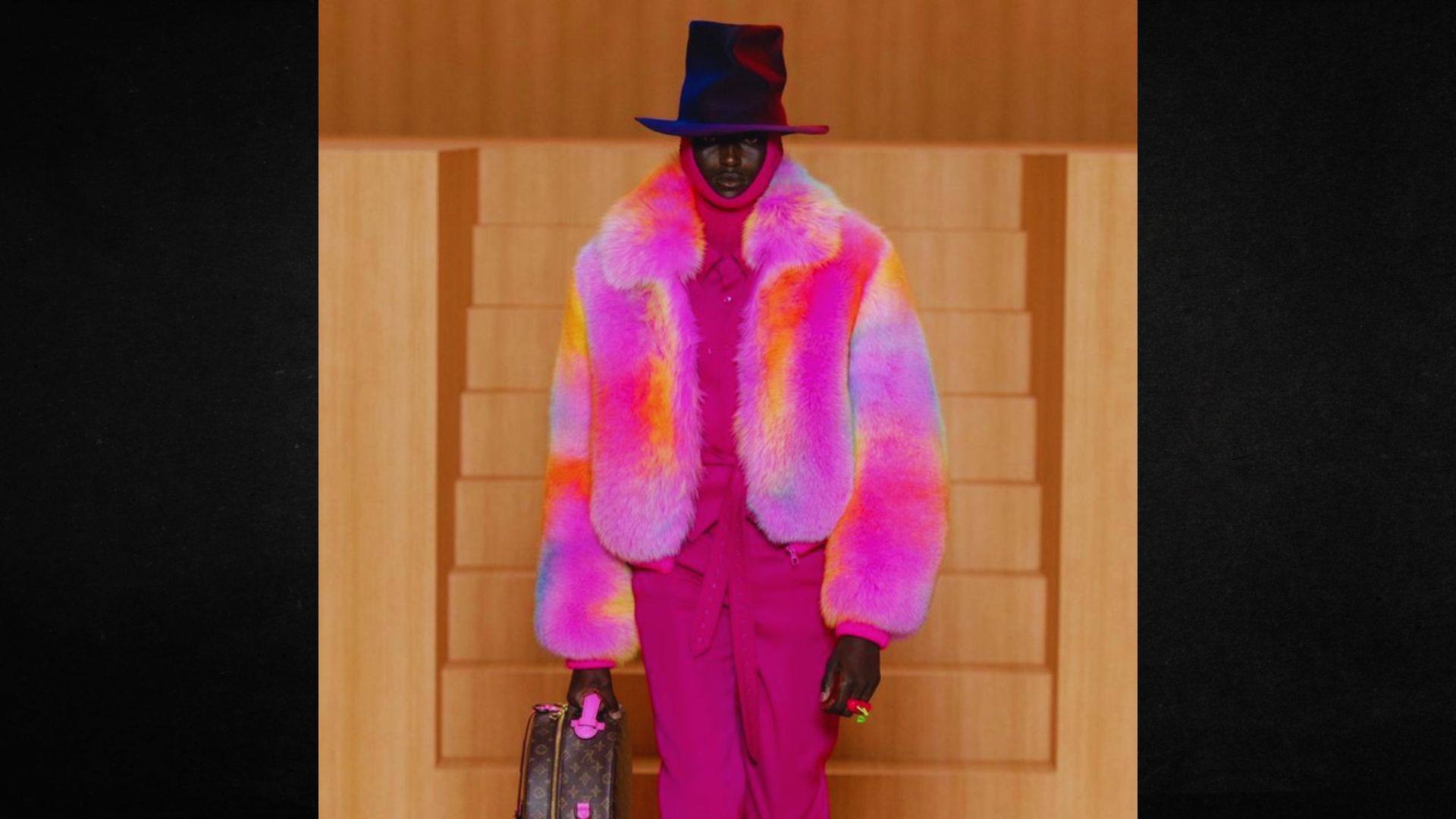 A man wearing a vibrant fur coat and matching hat, showcasing a bold and colorful fashion statement.