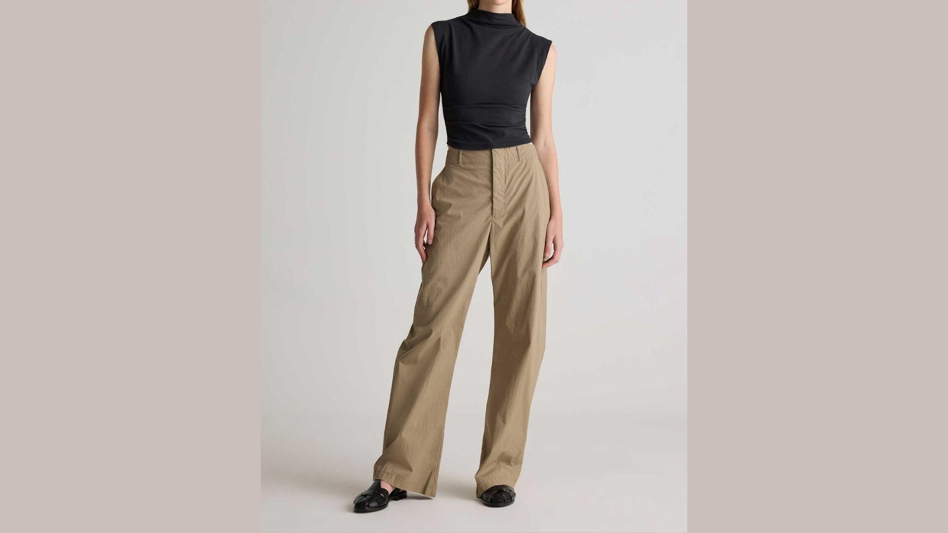 High-rise trousers displayed on a mannequin, showcasing a sleek design and modern fabric in a neutral color.