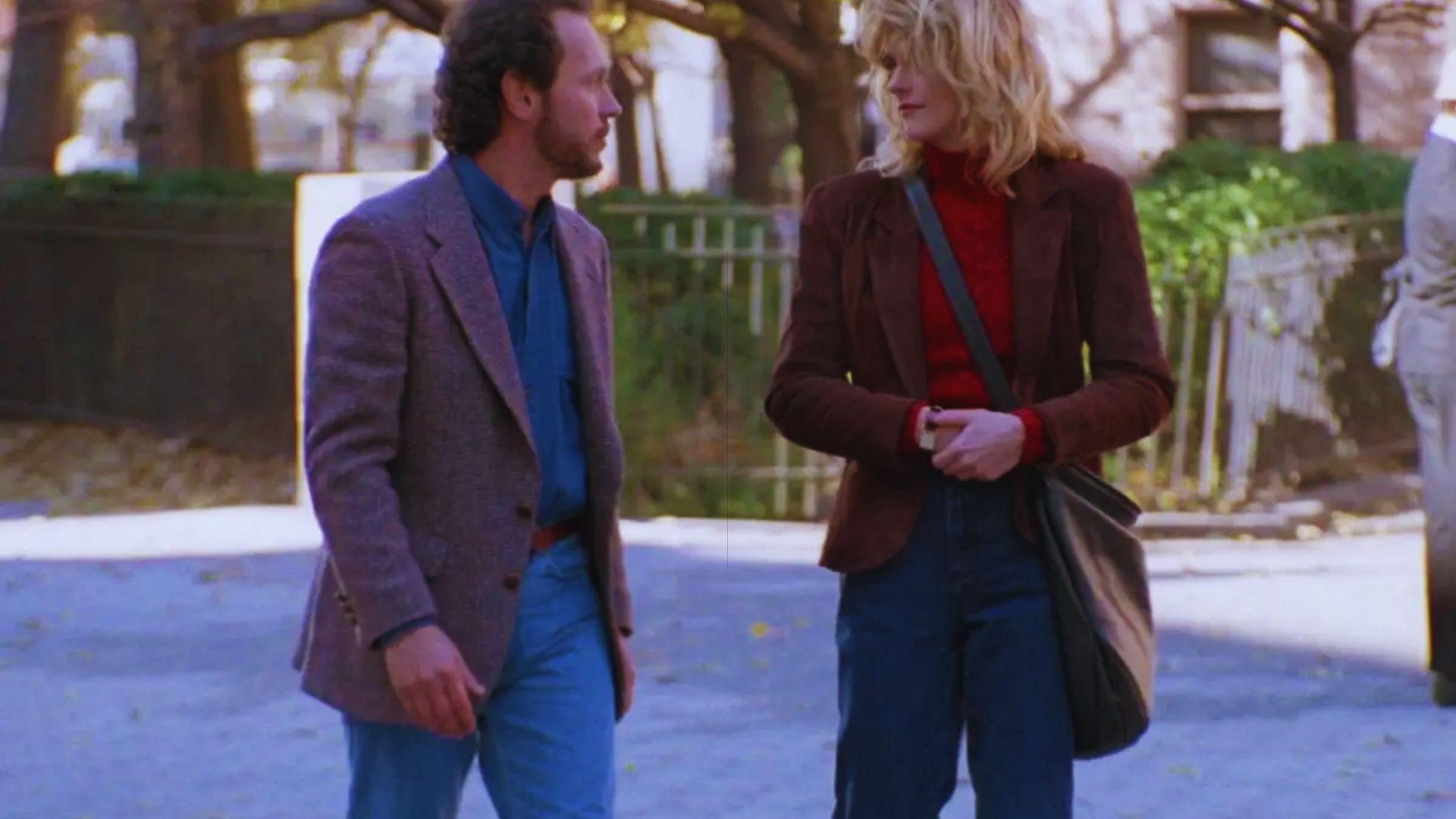 A man and woman engaged in conversation while standing on a city street.