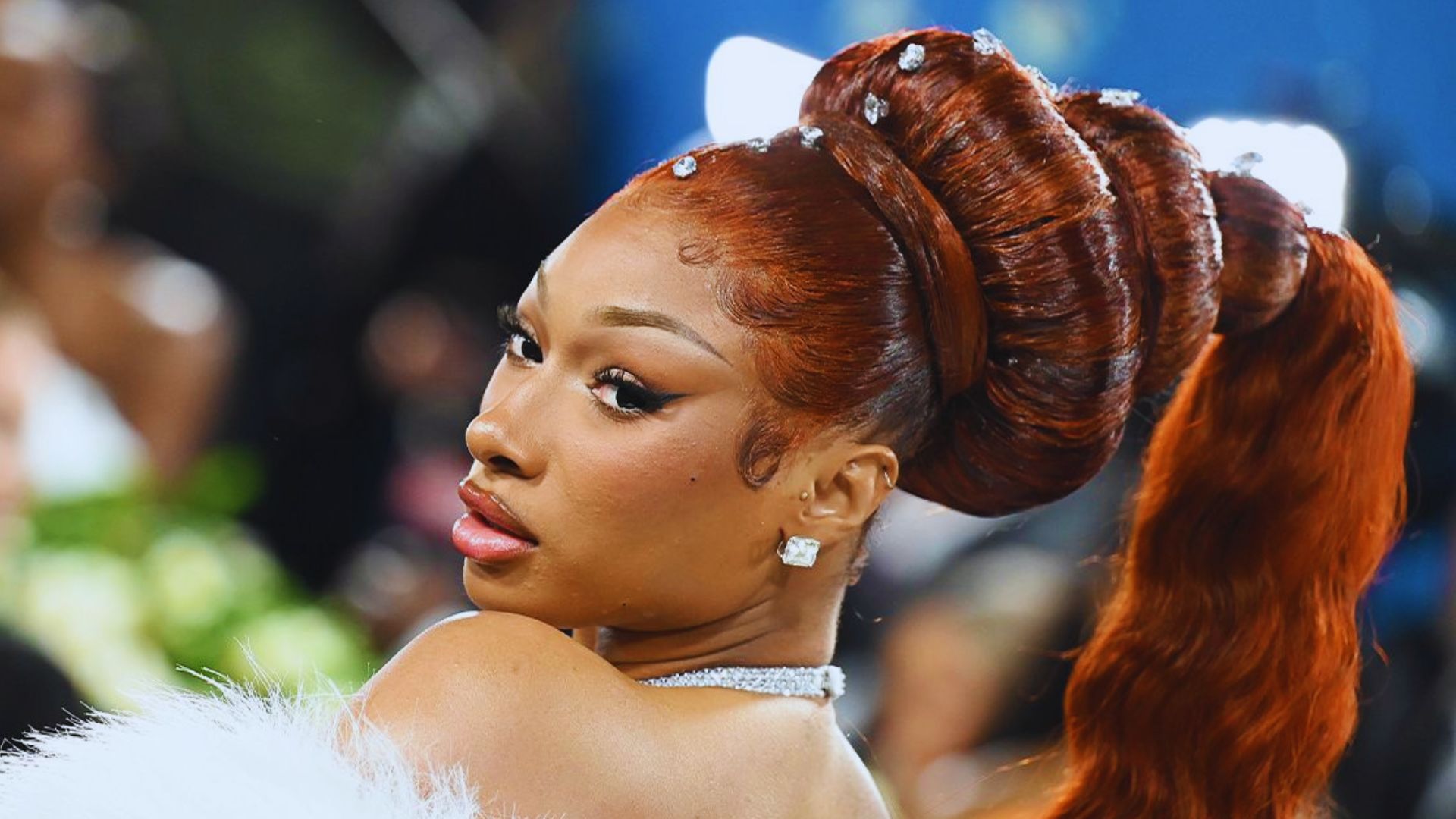 Nicki Minaj's long hair cascades down, nearly brushing her face, creating a striking and dramatic look.