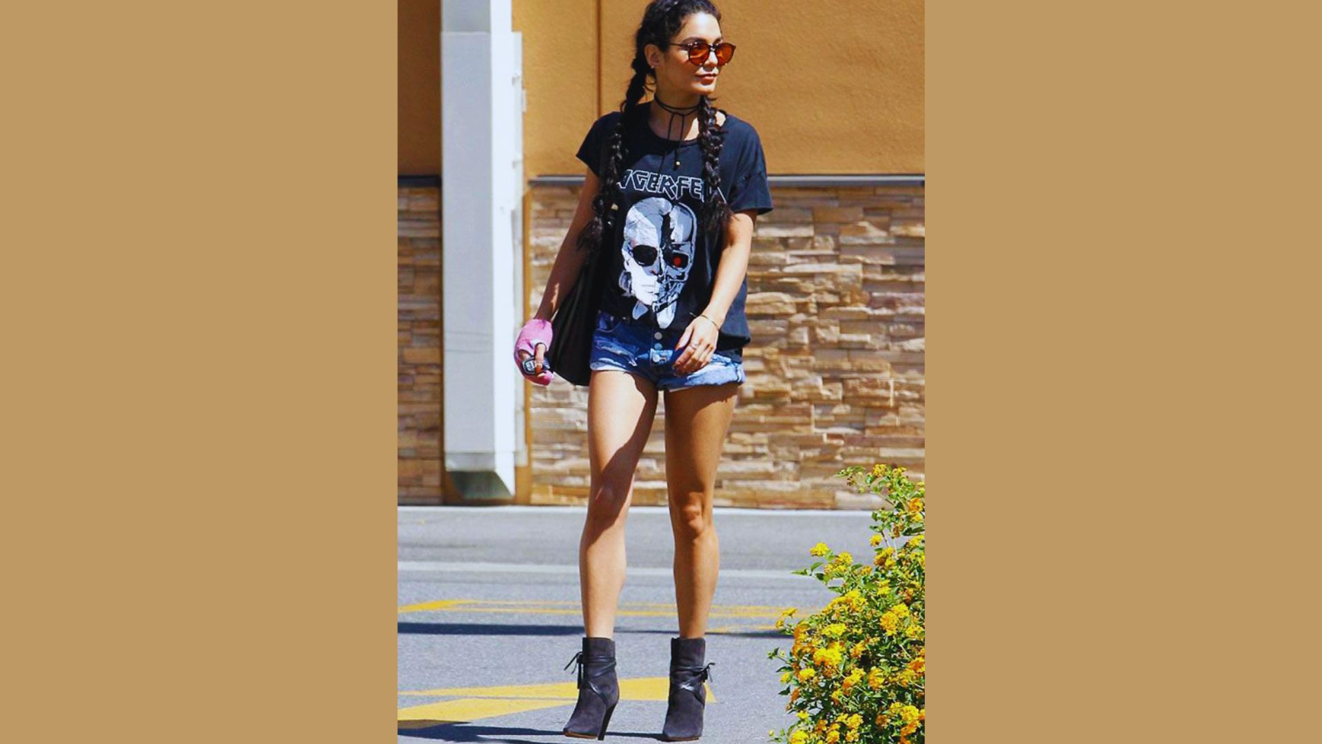 A woman in a black shirt and shorts walking along a city street on a sunny day.