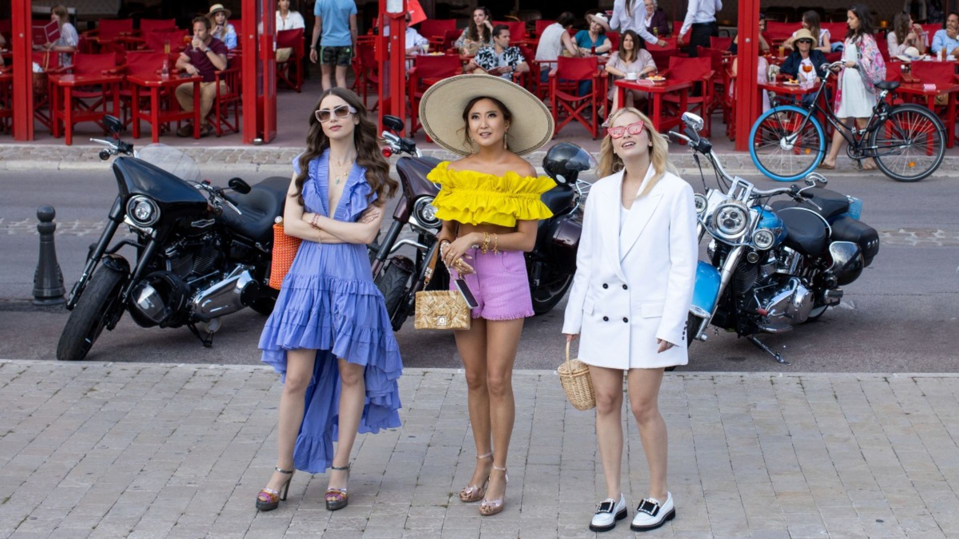 1. Three women in vibrant outfits pose beside motorcycles, showcasing a lively and adventurous spirit.