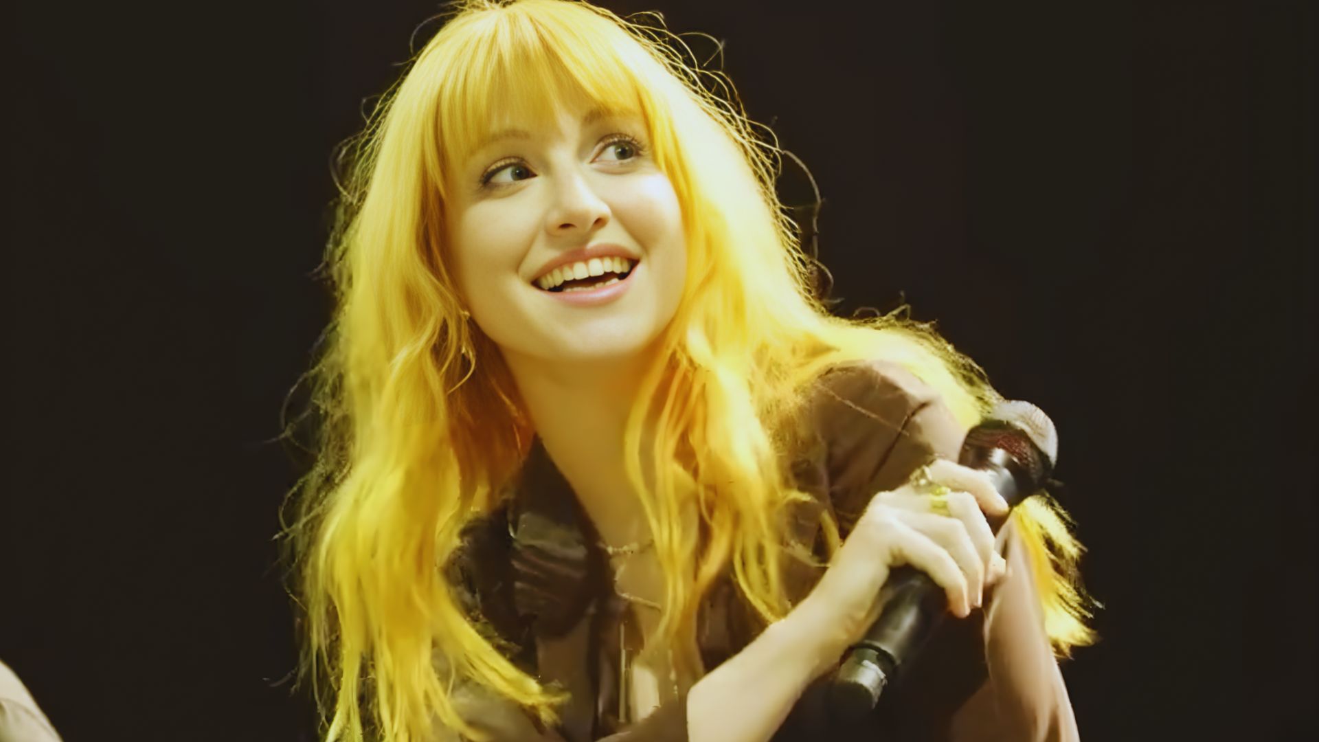 . A smiling woman with bright orange hair radiates joy.