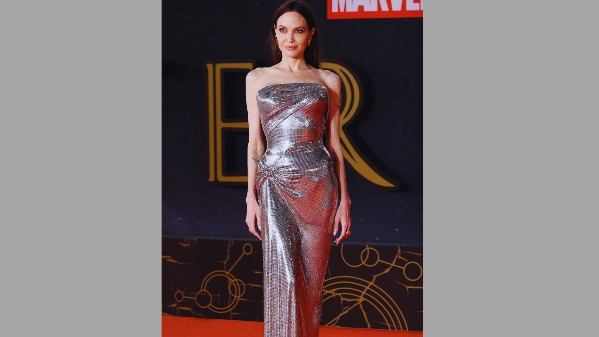 Angelina Jolie in a silver gown, showcasing monochrome neutral styling at the Star Wars: The Force Awakens premiere.