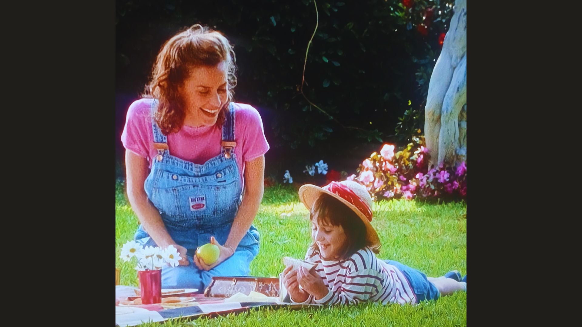 A woman and a girl playing and relaxing in a garden.