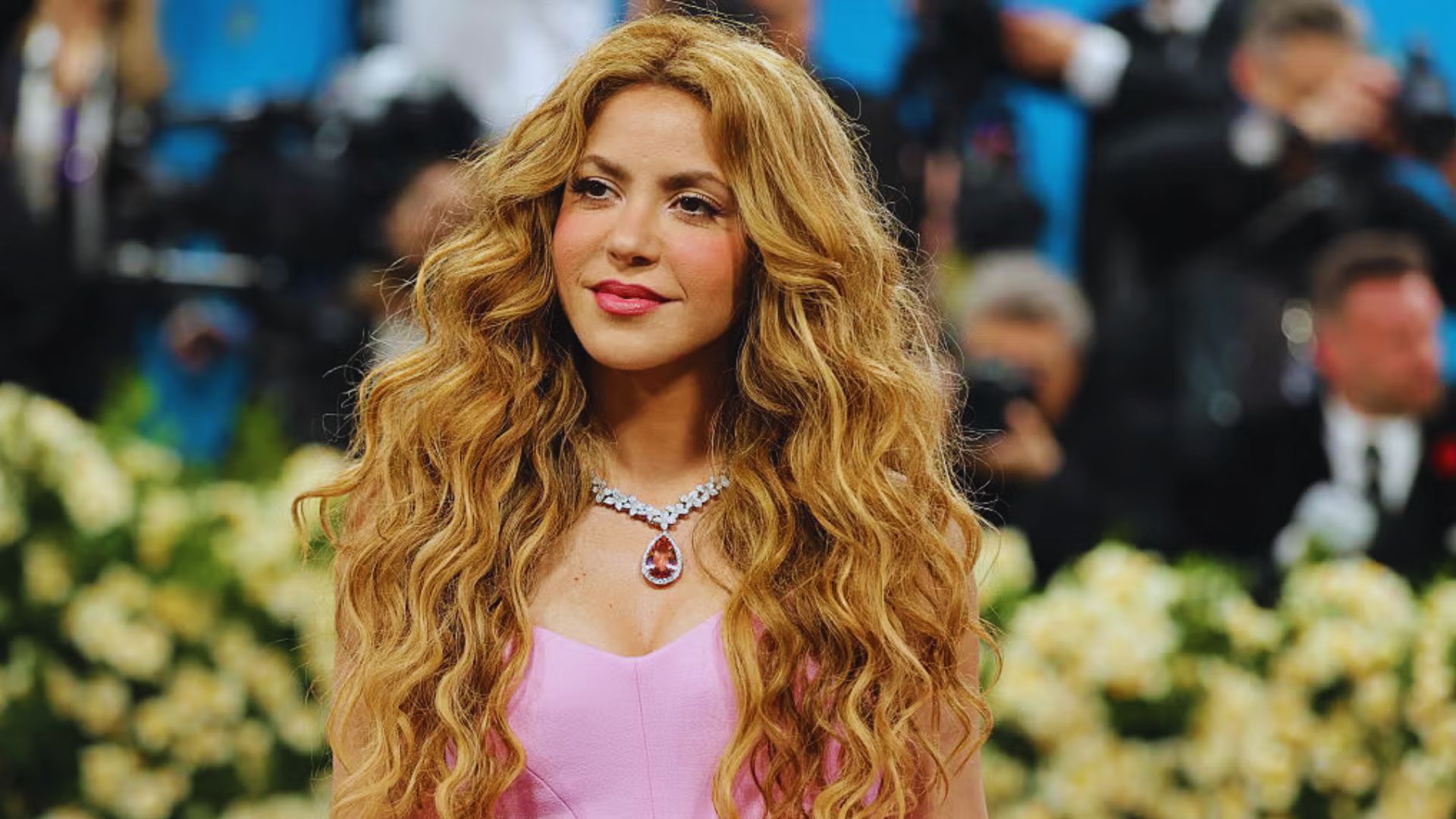 Shakira with curly hair on a carpet, showcasing her own style and fashion sense.
