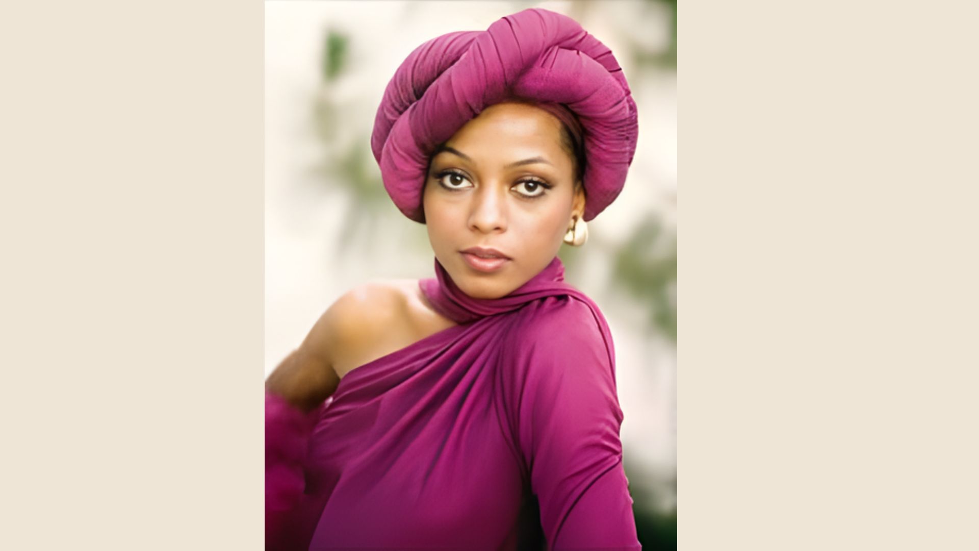 1. A woman in a purple turban and a pink dress stands confidently, showcasing her vibrant and stylish outfit.