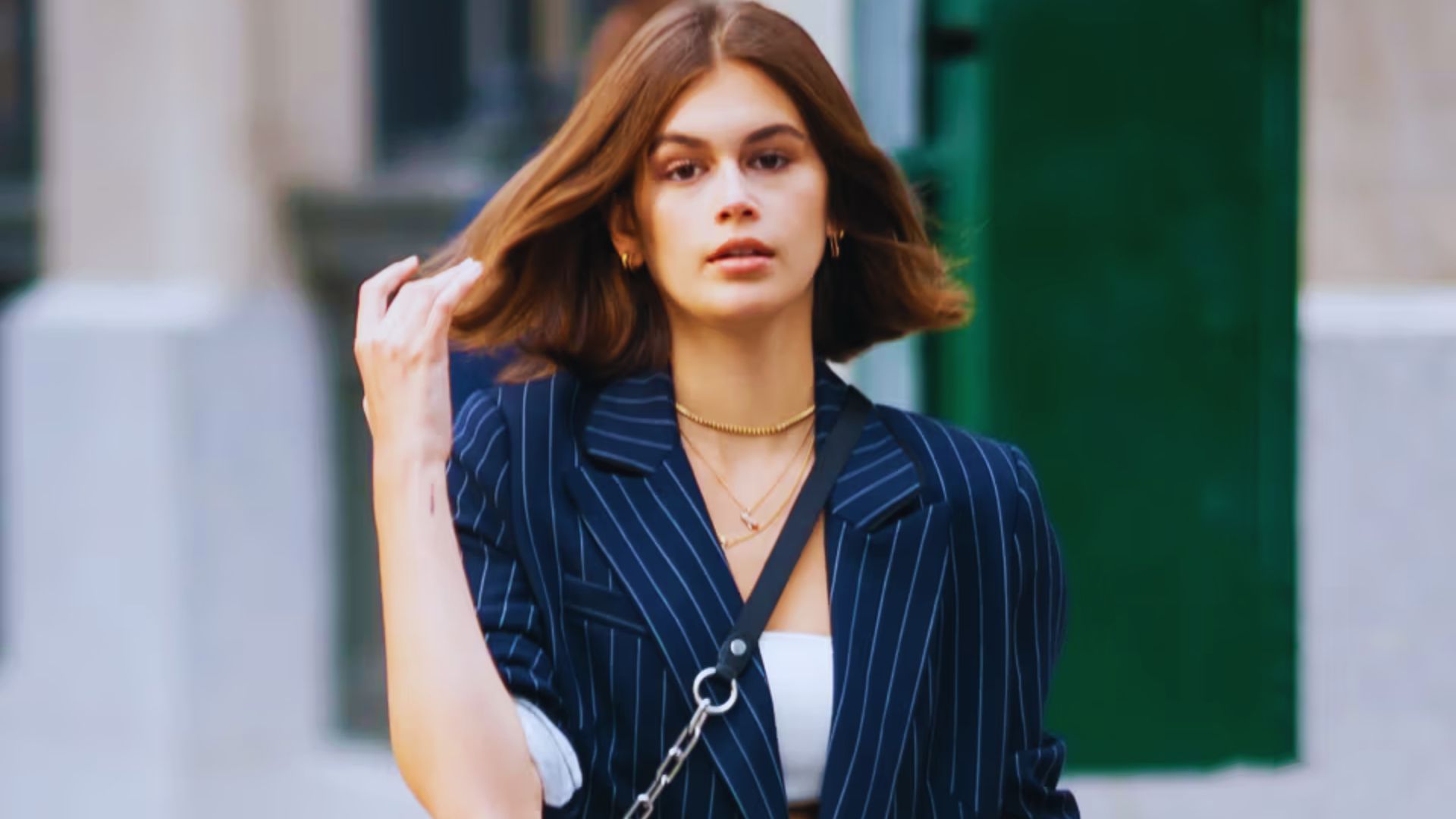 A woman in a blue pinstripe suit and white top, showcasing a stylish and formal appearance.