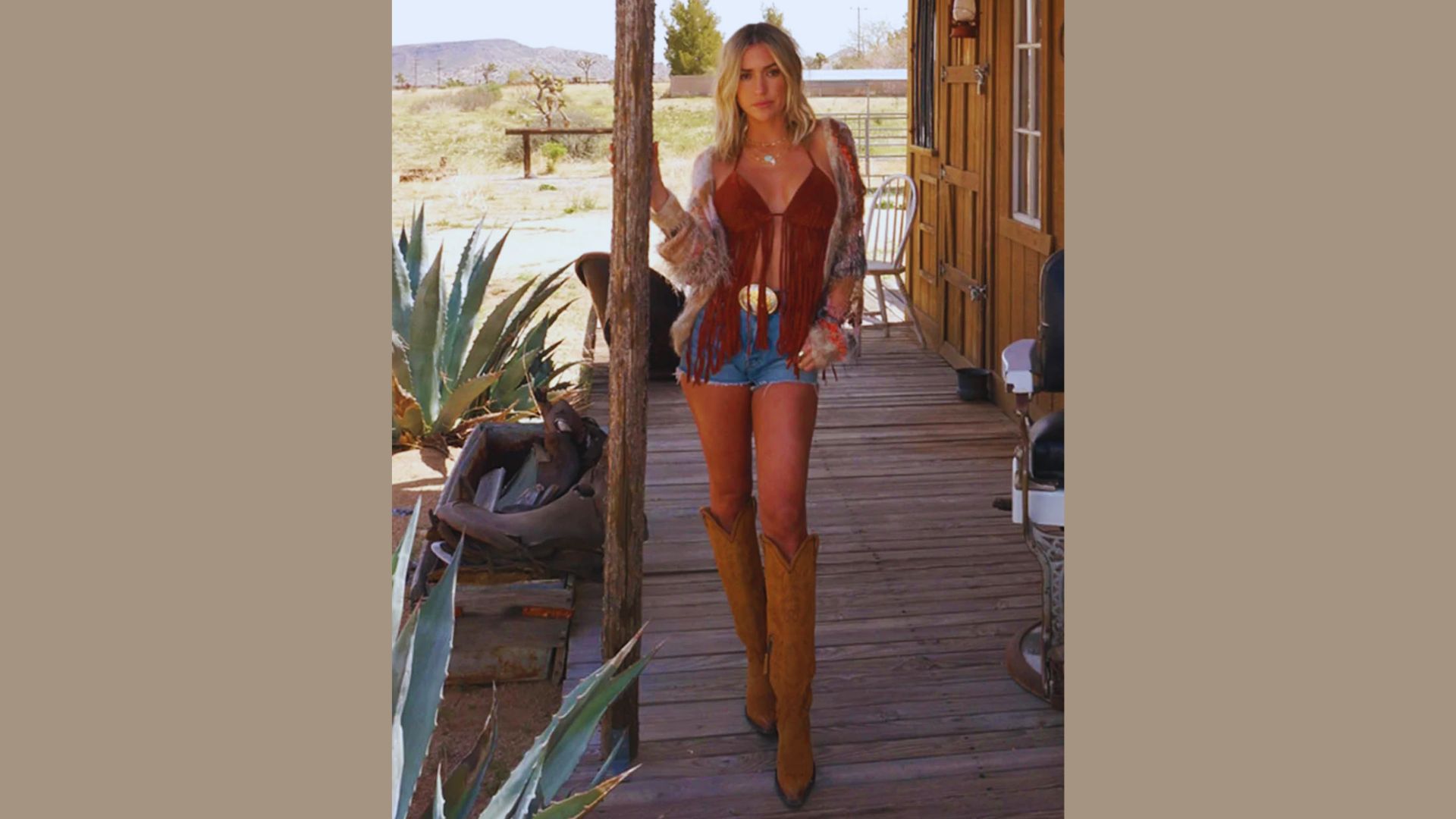 A woman wearing cowboy boots stands confidently on a wooden porch, enjoying the outdoors.