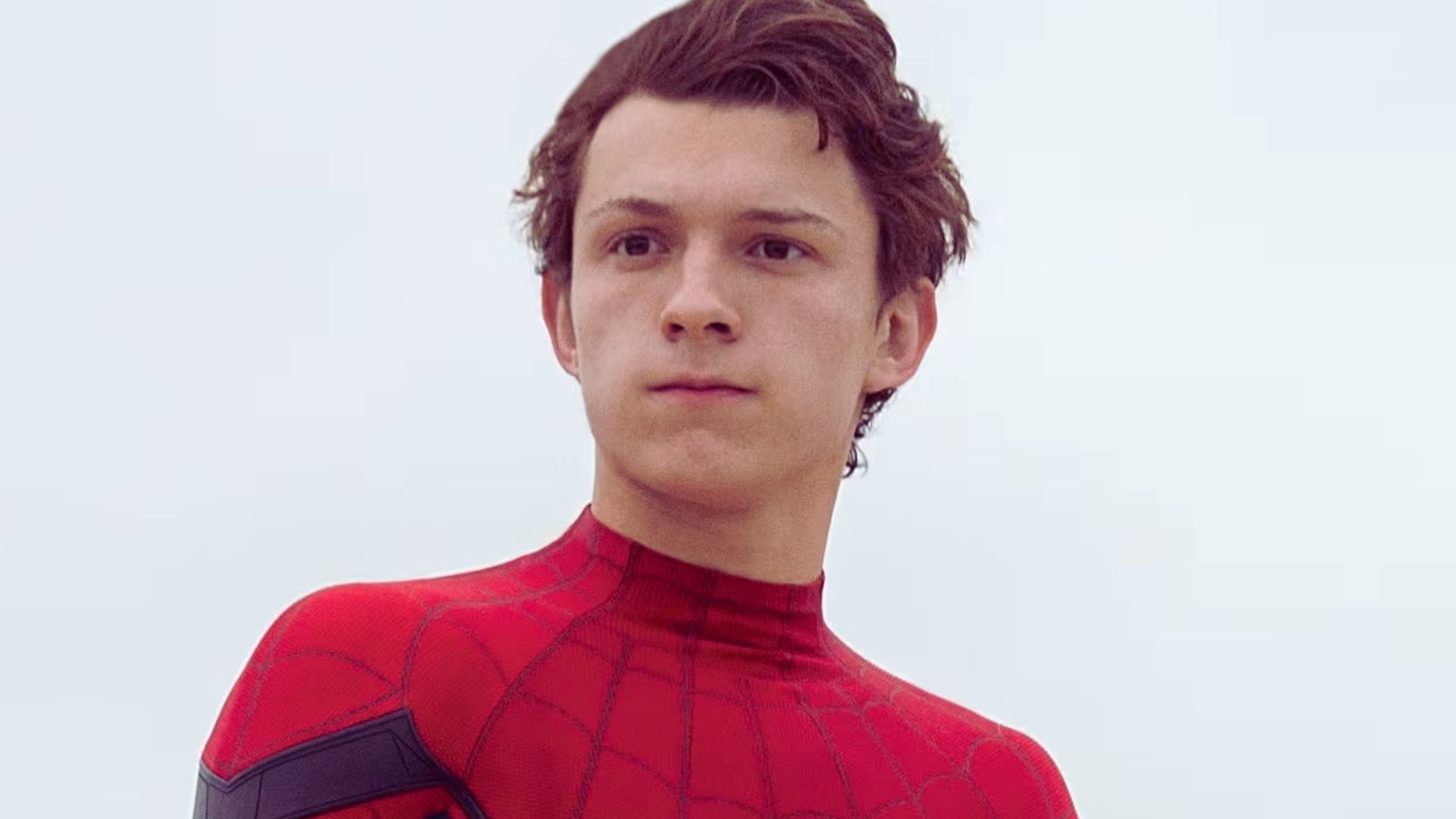 Tom Holland as Spider-Man in the latest Spider-Man movie, showcasing his iconic suit and dynamic pose.