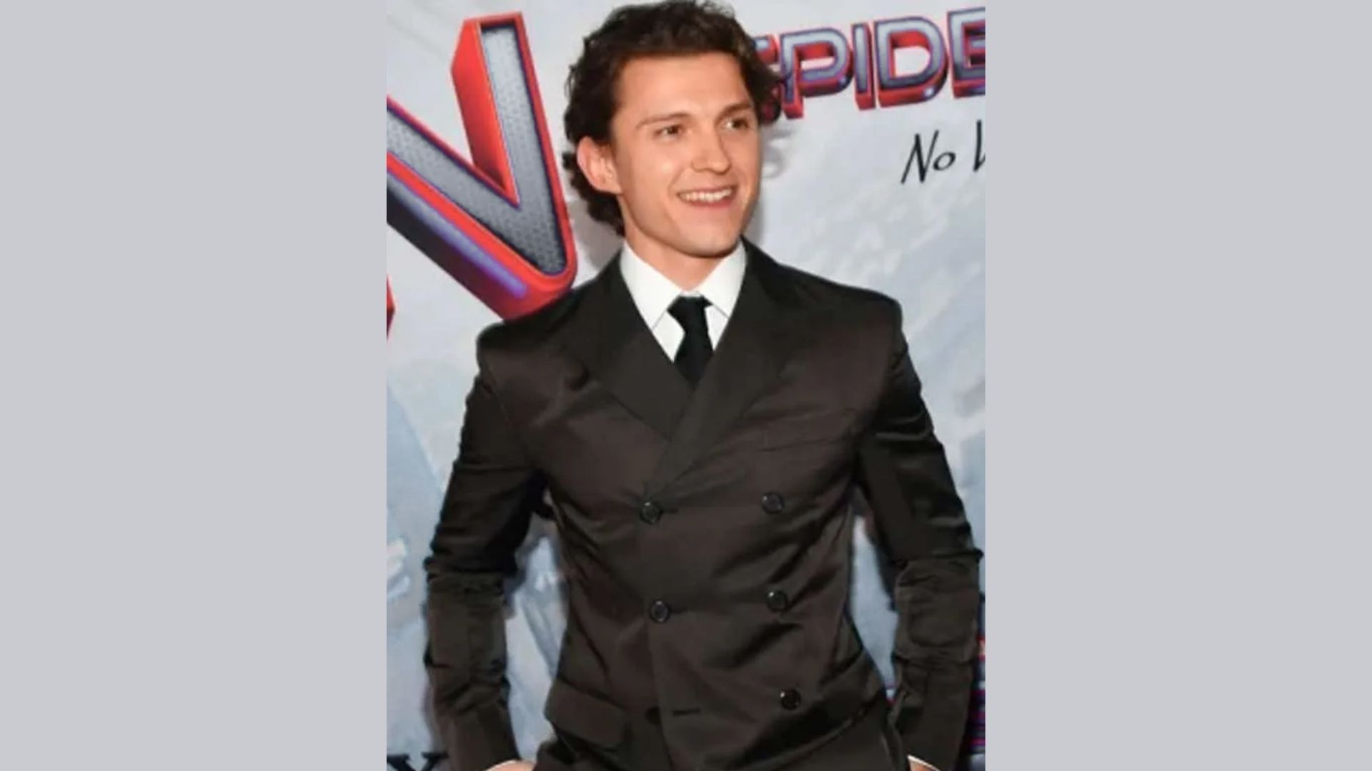Tom Holland in a brown double-breasted suit and tie, showcasing a stylish and sophisticated look.