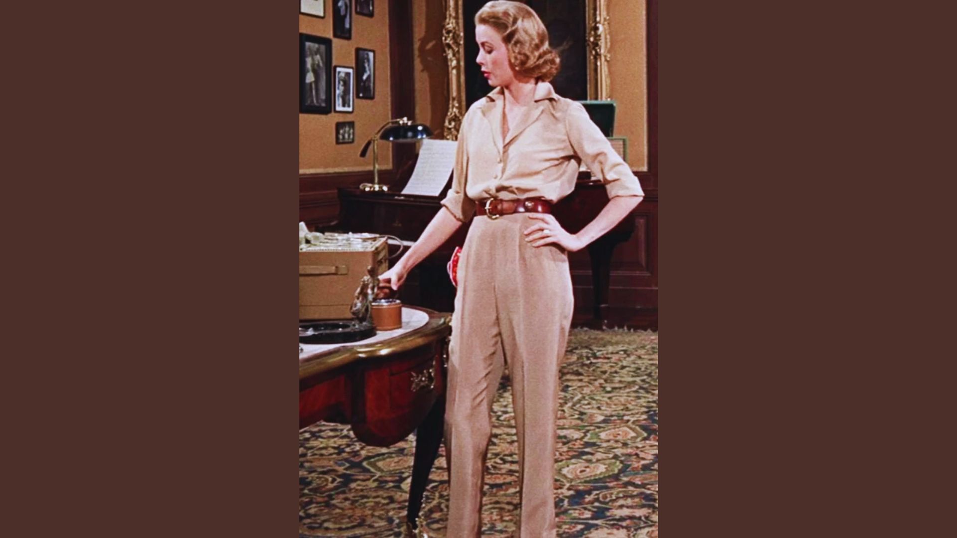 1. A woman in a tan suit stands beside a desk, exuding professionalism in a modern office setting.