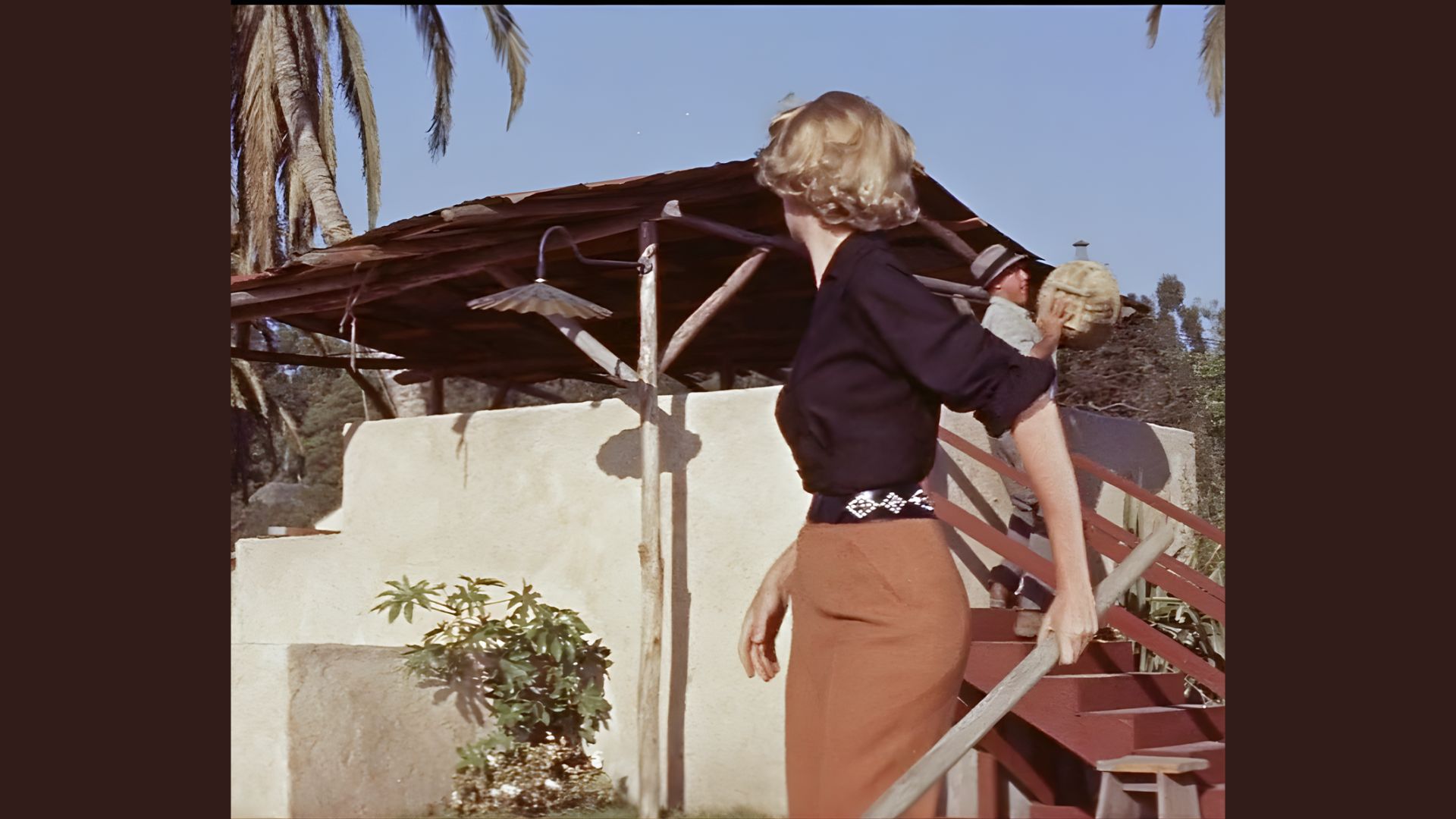 1. A woman in a black shirt and orange pants ascends a staircase, focusing on her steps.