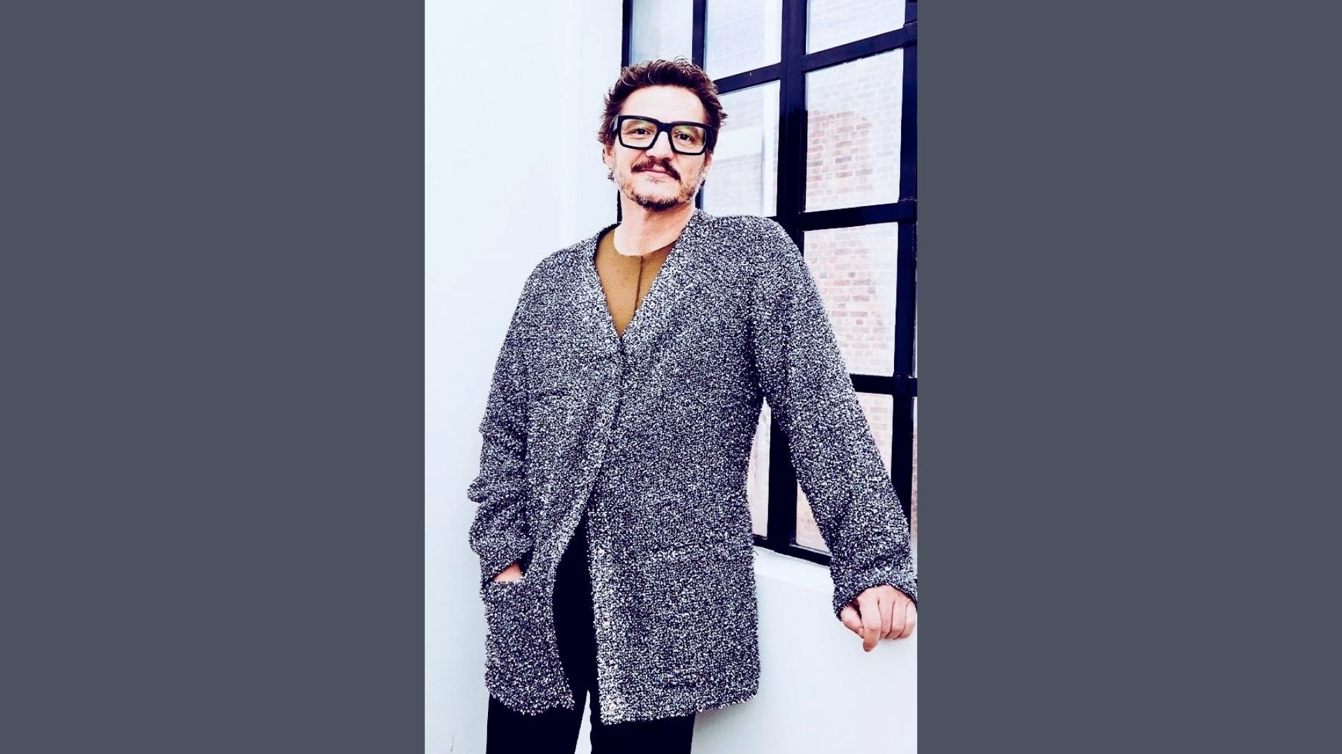 1. A man with glasses wearing a sweater, looking thoughtfully to the side.