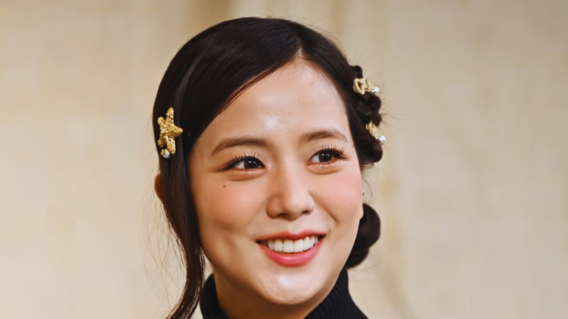 A woman with black hair adorned with an elegant gold headpiece, showcasing a regal and sophisticated appearance.