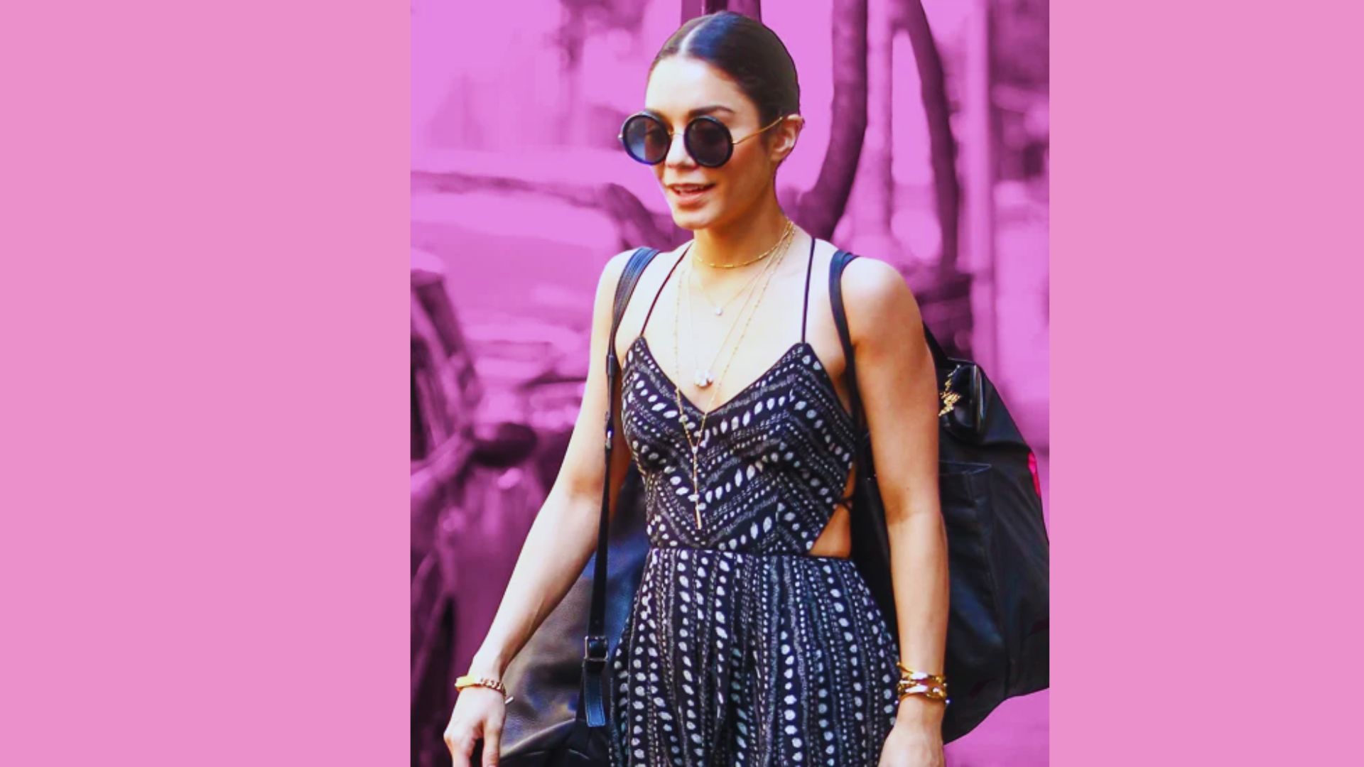 A woman wearing a black dress and sunglasses strolls along the street, exuding elegance and style.
