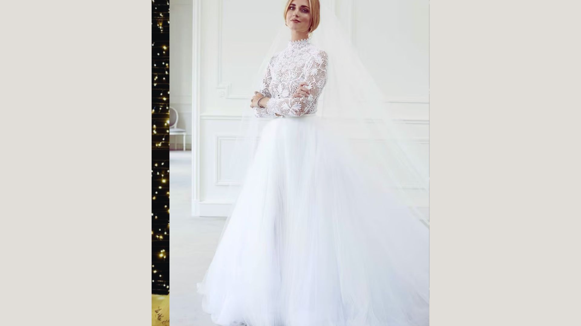 A woman in a wedding dress poses elegantly for a photo, showcasing her joyful expression and beautiful attire.