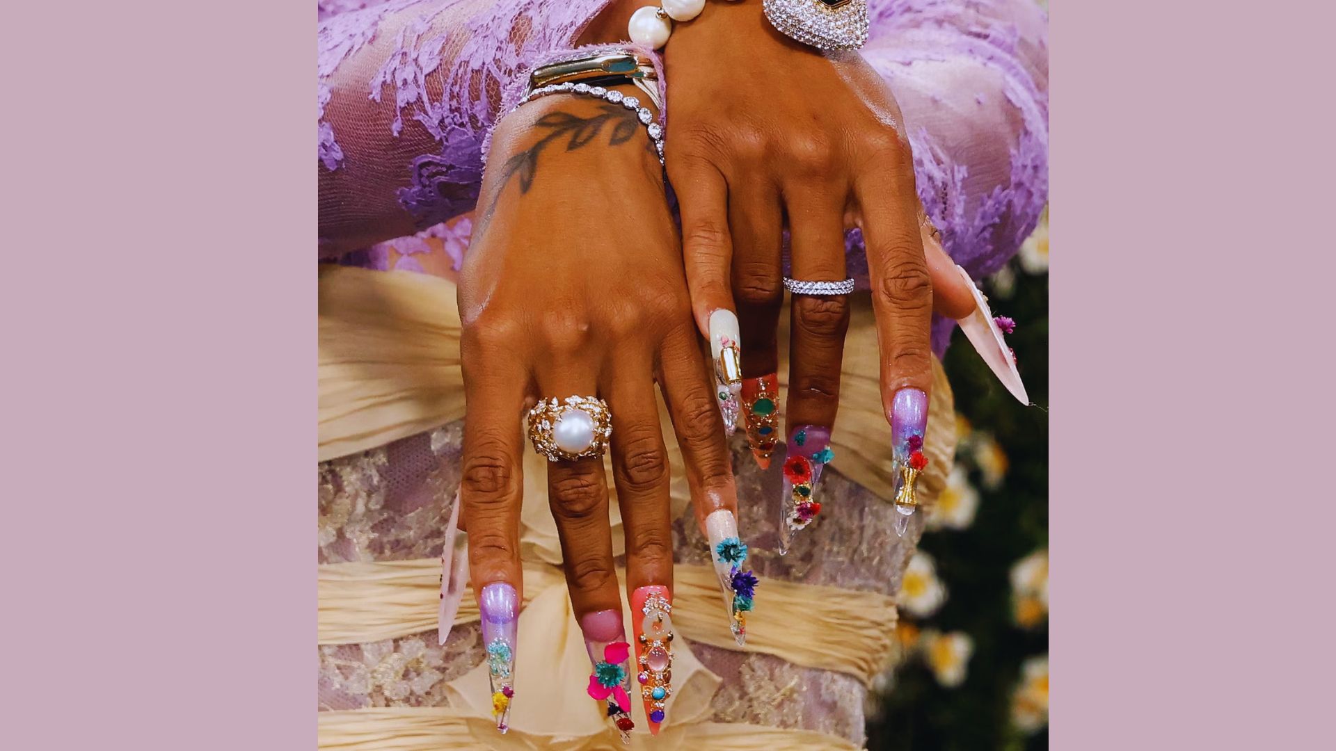 A close-up of a woman's hands showcasing colorful nails and rings, highlighting Sha'Carri Richardson's Met Gala 2025 style.