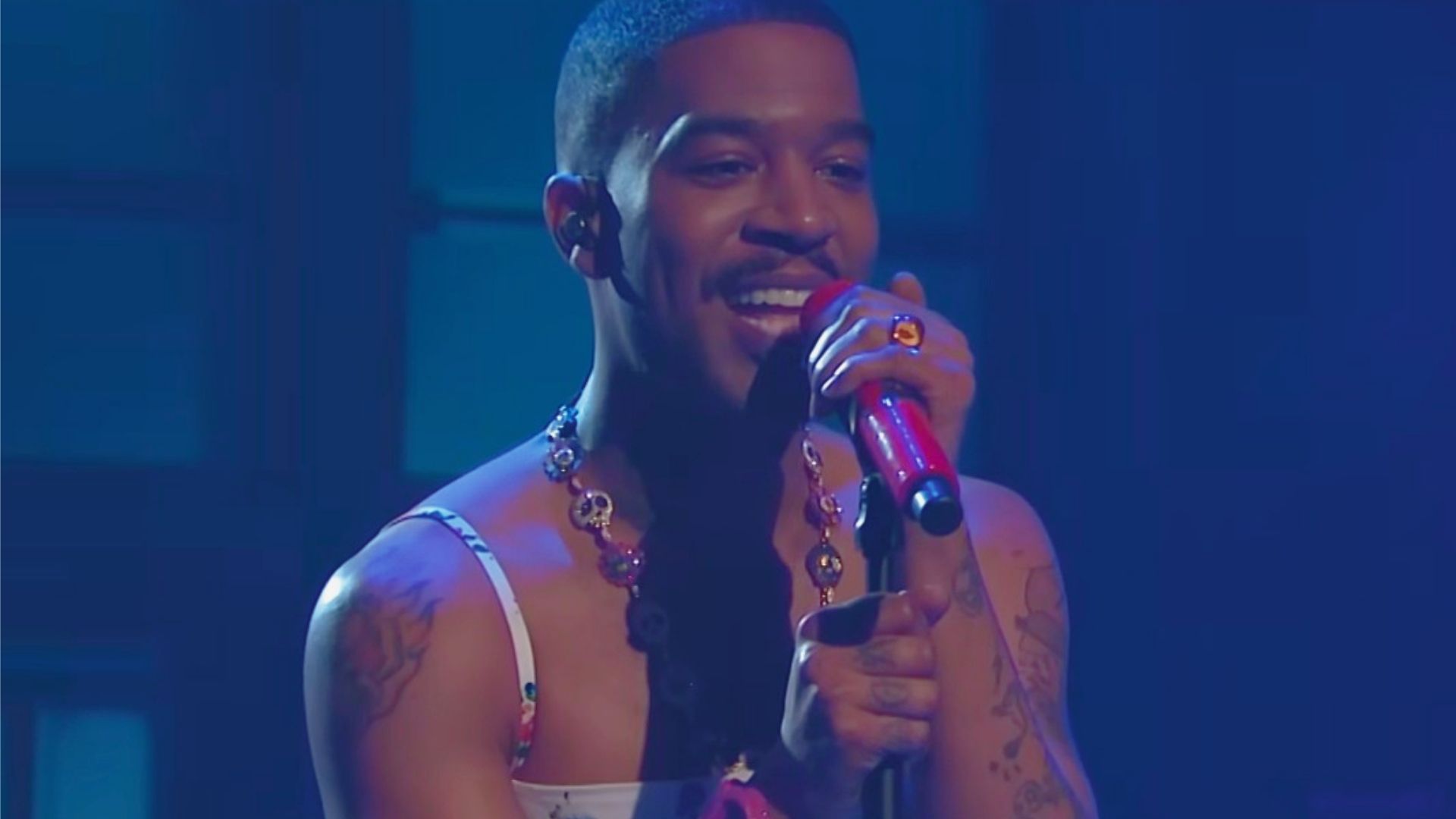 A tattooed man passionately singing into a microphone, embodying the spirit of performance and expression.