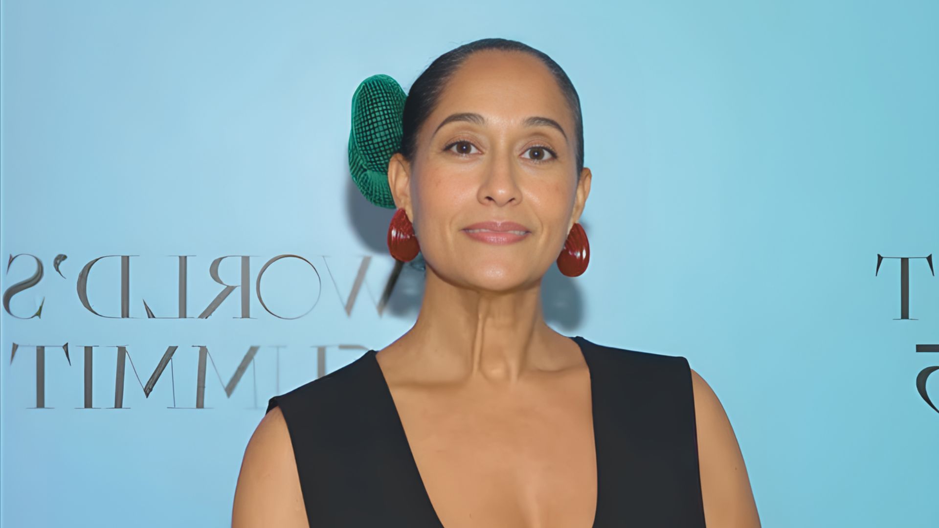 A woman wearing a black dress and bold earrings, embodying the theme of "Accessorize Boldly."