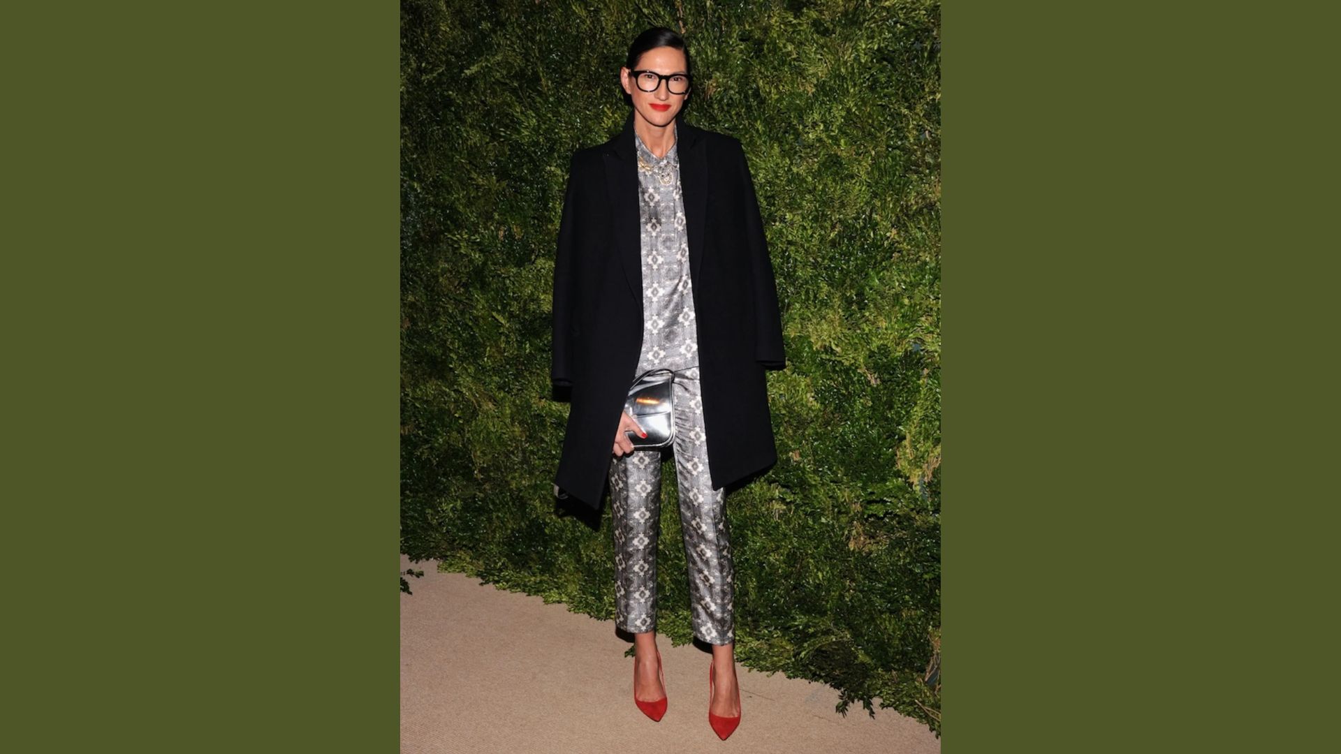 A woman dressed in a sleek silver suit and coat, showcasing a modern and fashionable look.