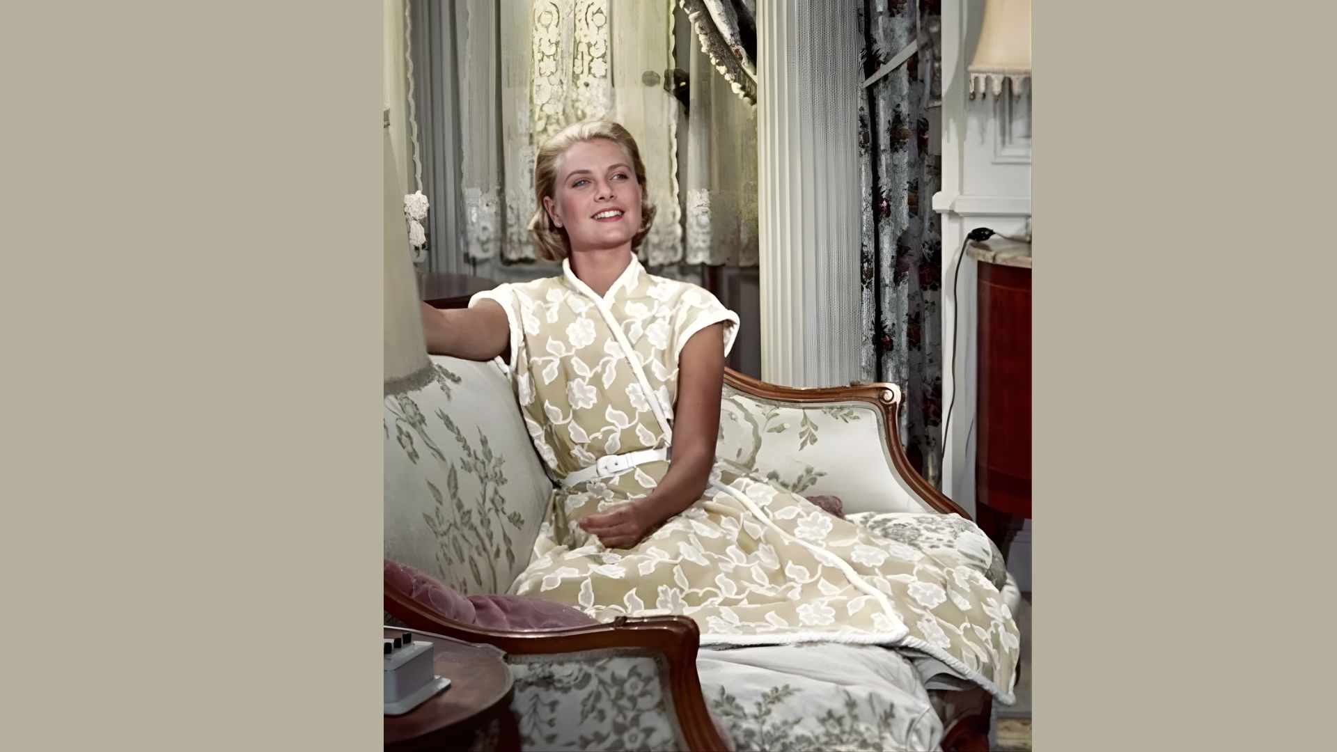 2. A woman wearing a white dress is seated on a couch, appearing serene and comfortable in her surroundings.
