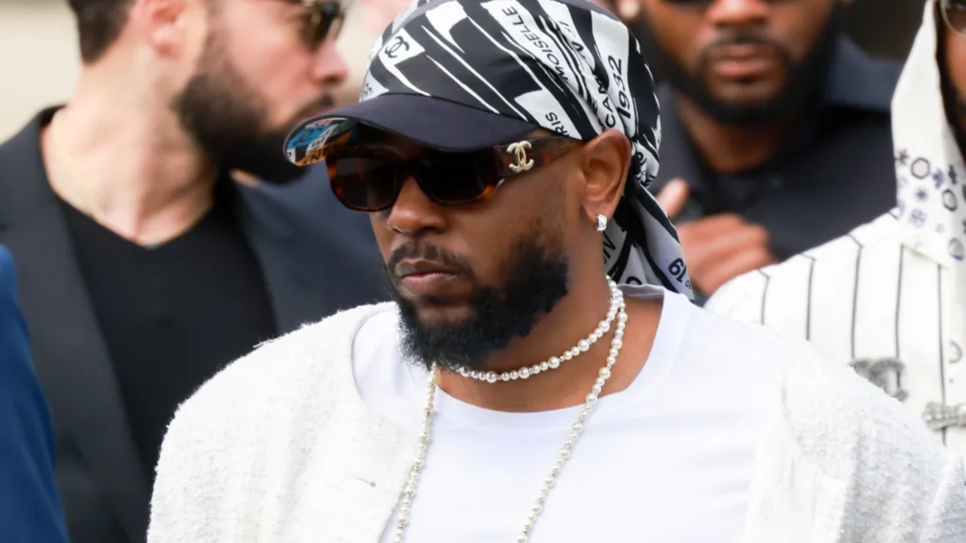 A man with a beard wearing a bandana on his head, looking confidently at the camera.