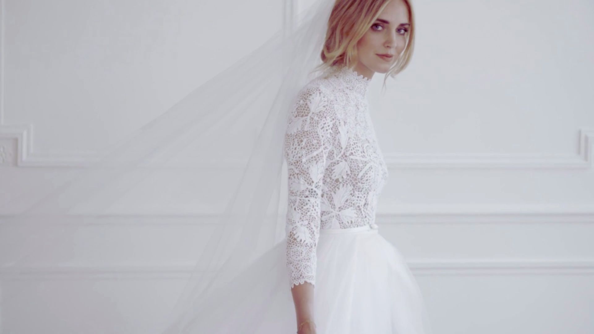 A bride wearing a white wedding dress and veil, radiating elegance and joy on her special day.