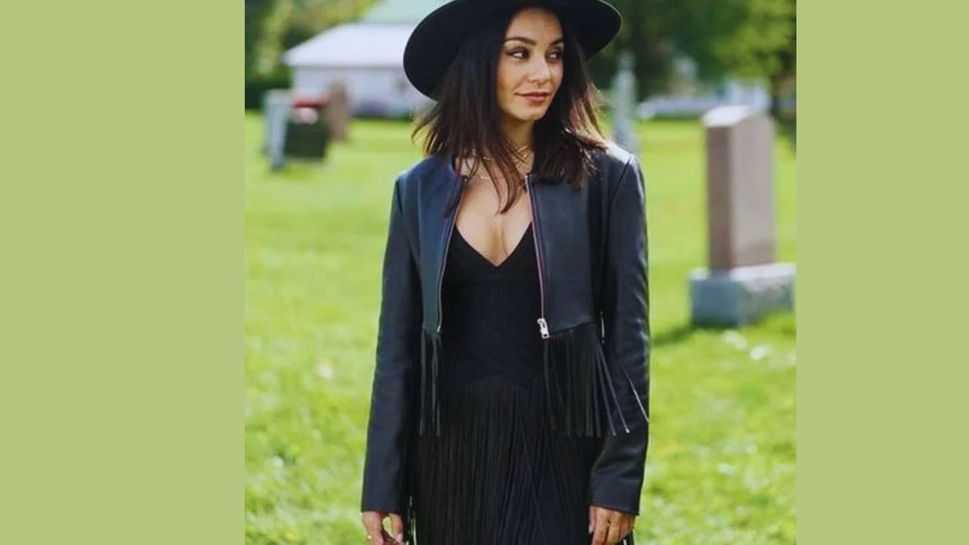 A woman in a black dress and hat stands solemnly in a cemetery, surrounded by gravestones and greenery.