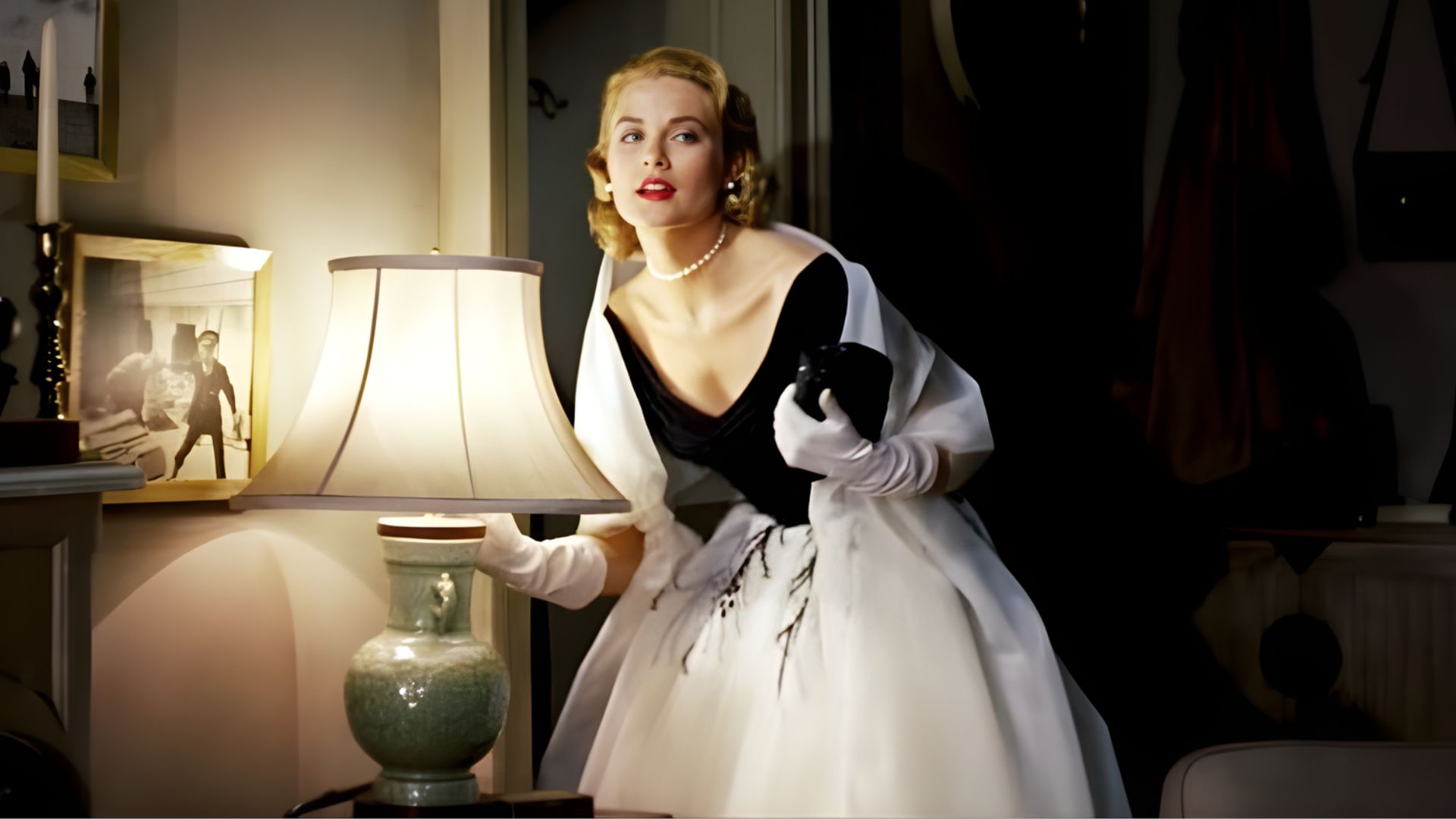 3. A woman in a white dress and gloves stands next to a lamp, highlighting a refined and stylish atmosphere.