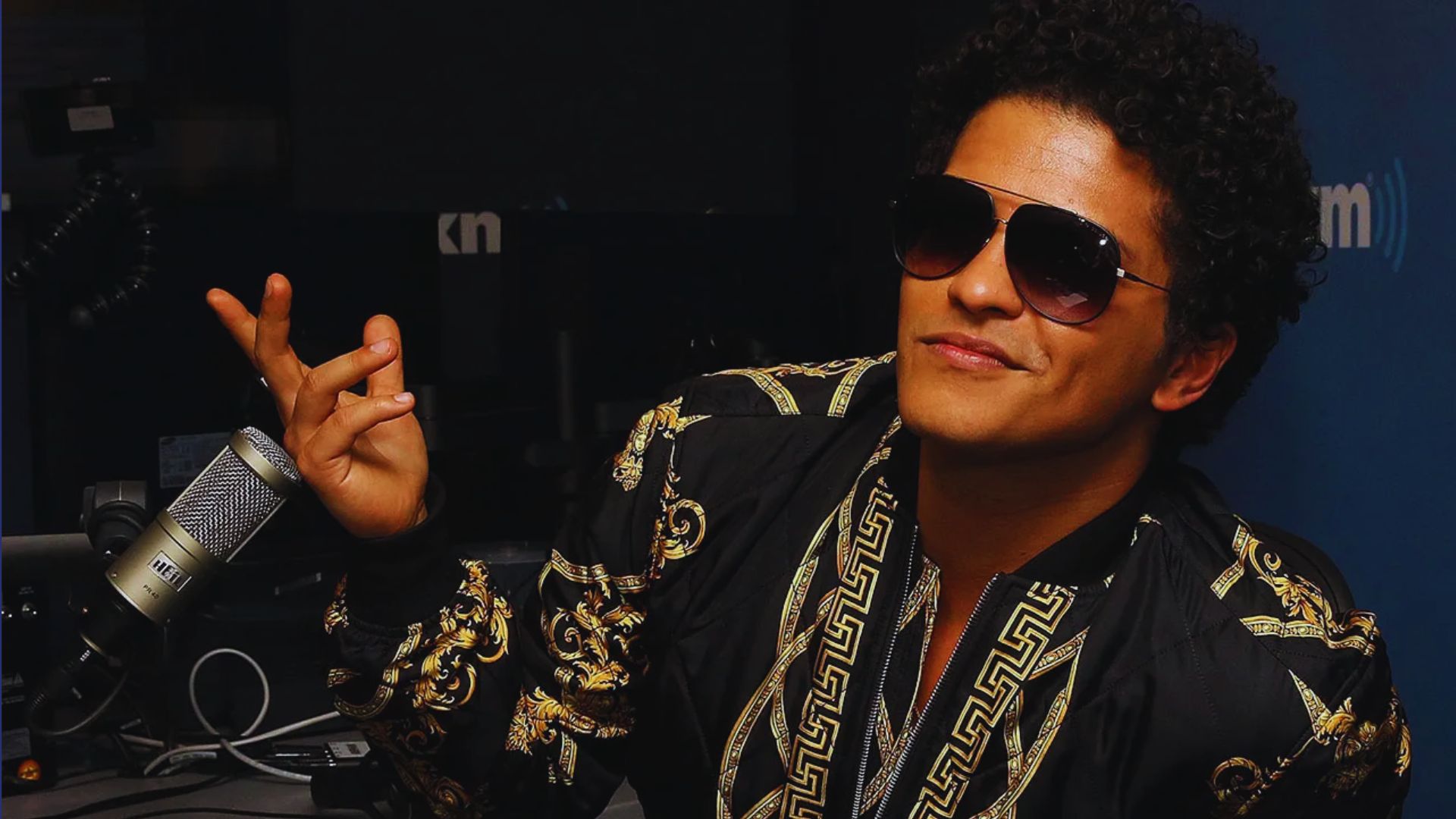 Bruno Mars in stylish sunglasses, probably in a podcast or interview.