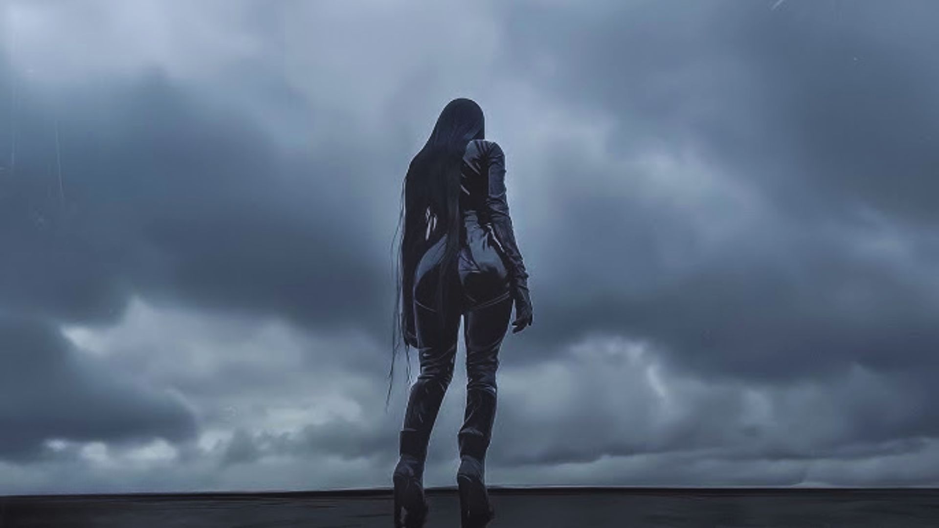 A woman dressed in black stands confidently on a dark surface, creating a striking contrast in the image.