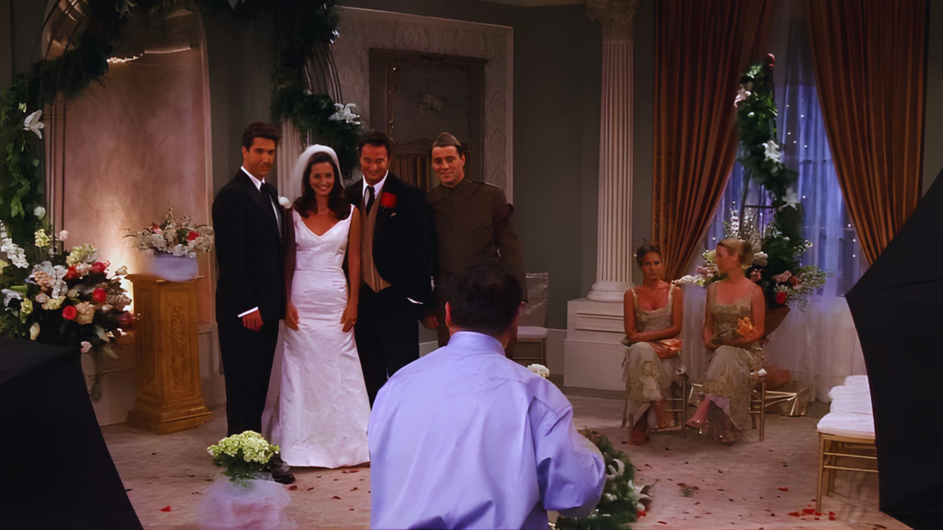A wedding ceremony featuring a bride and groom standing together at the altar, surrounded by floral decorations and guests.