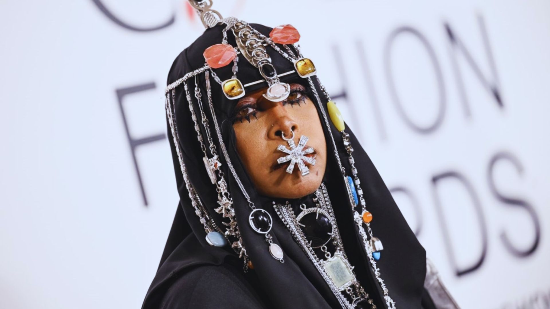 A woman adorned with a colorful headdress and intricate jewelry, showcasing cultural elegance and beauty.