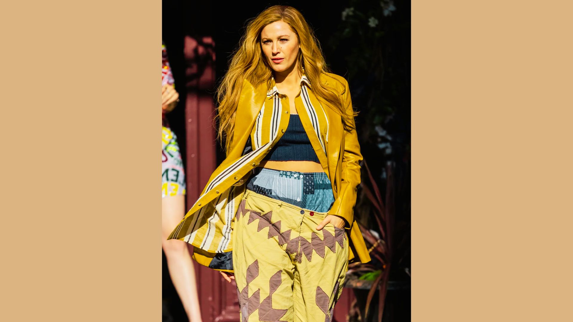 Blake Lively in a stylish yellow coat and pants, showcasing a vibrant fashion choice in a chic setting.