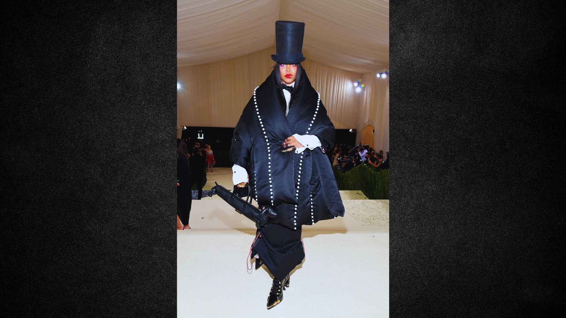 A man dressed in a stylish suit and top hat, representing formal attire and elegance.