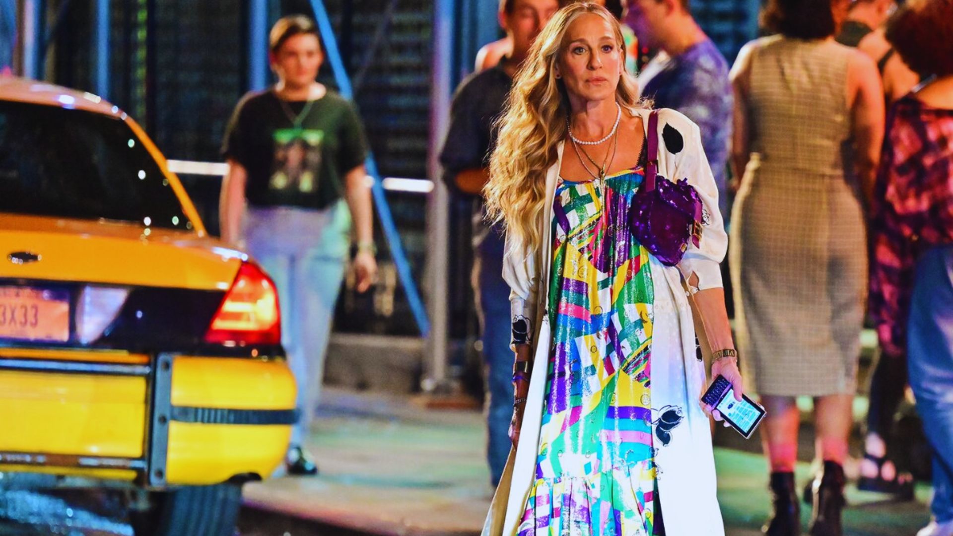 Blake Lively wearing a floral dress, smiling gracefully against a soft background.