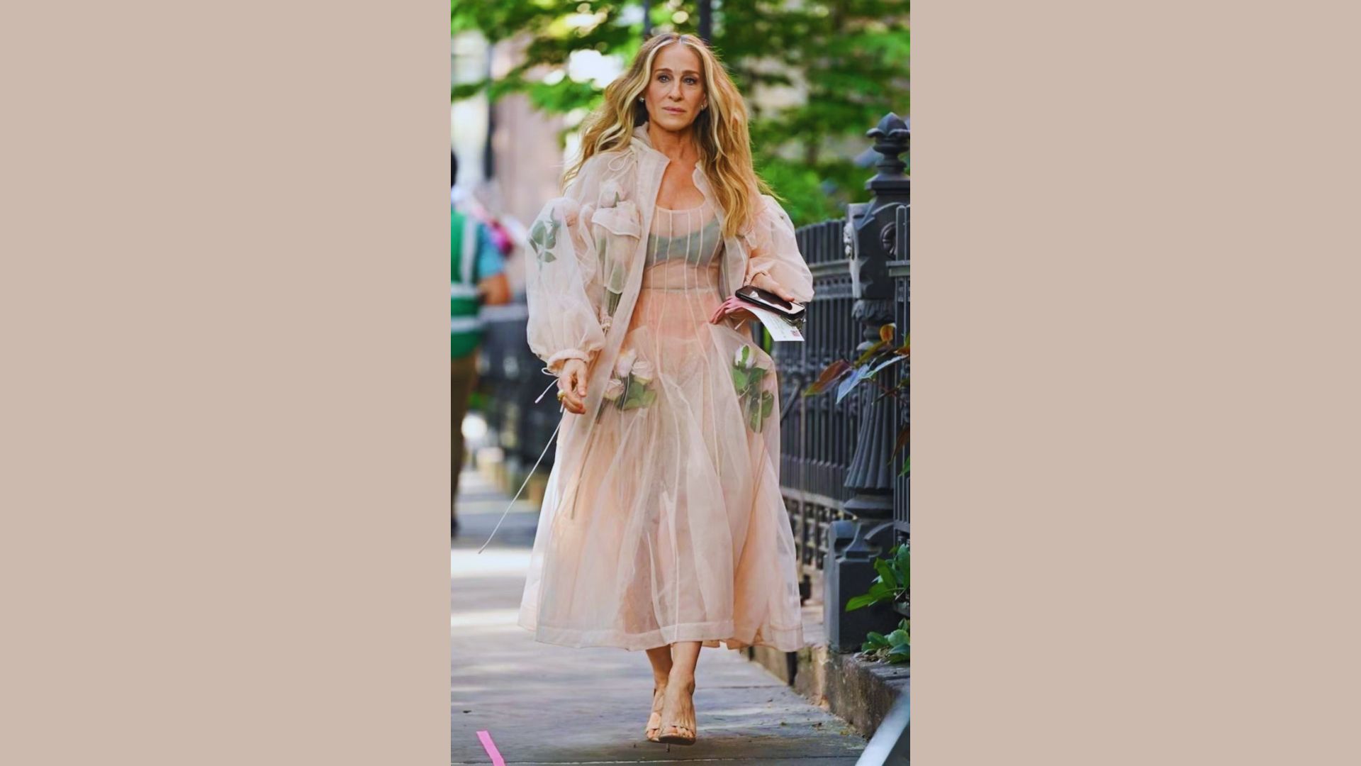 Person wearing a blush pink dress, standing gracefully with a soft smile in a serene outdoor setting.