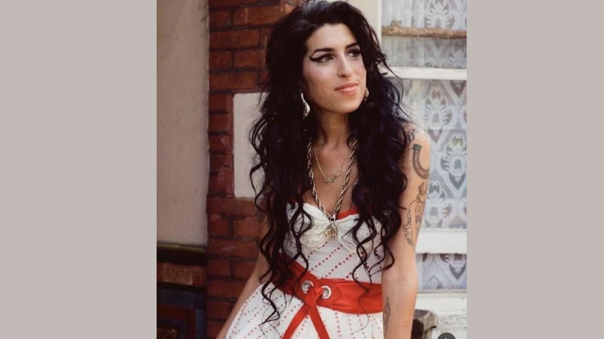 A woman with long hair wearing a flowing dress stands gracefully, showcasing her elegant style and poise