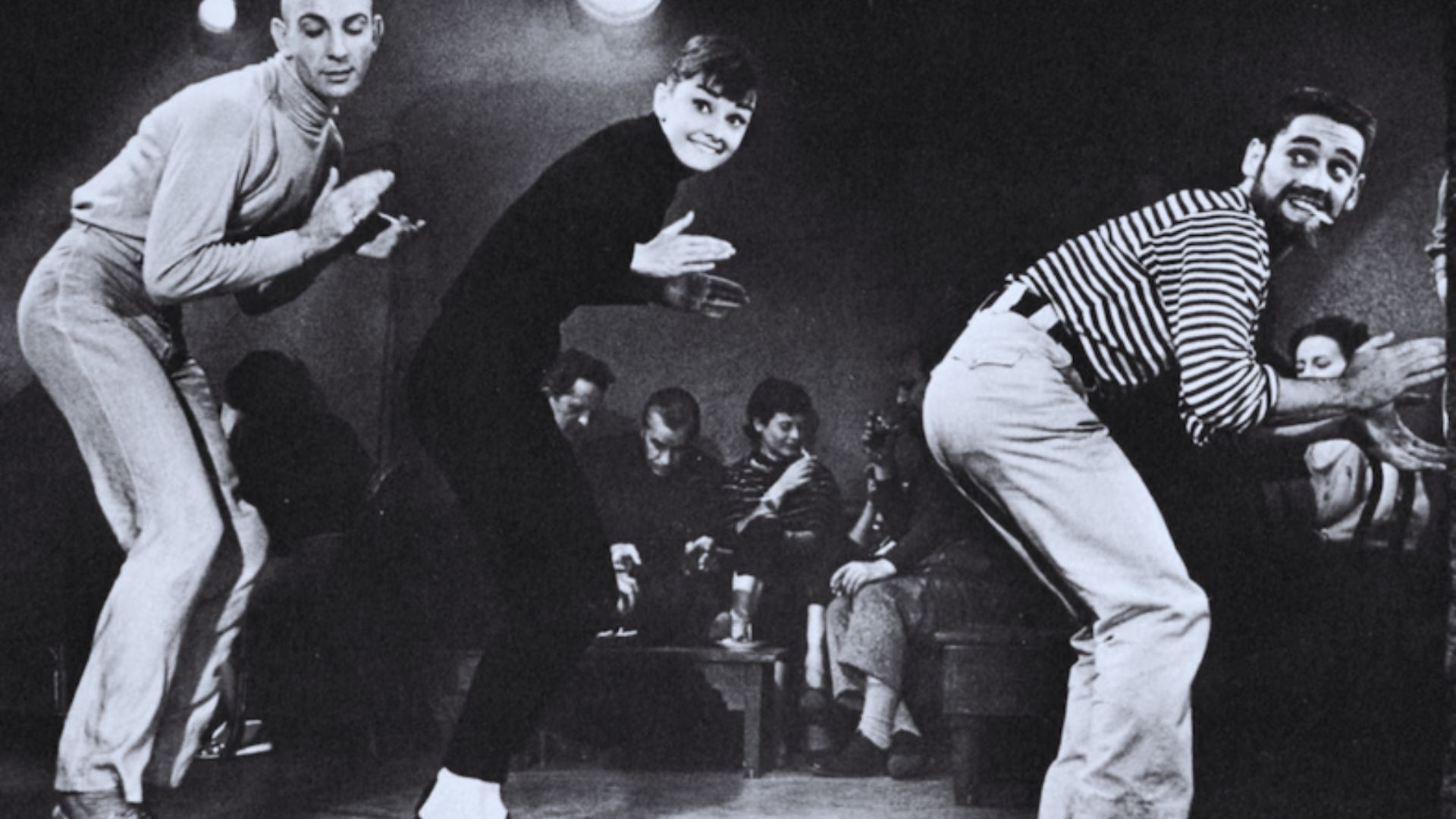 Several individuals enjoying a night out, dancing energetically in a colorful club setting.
