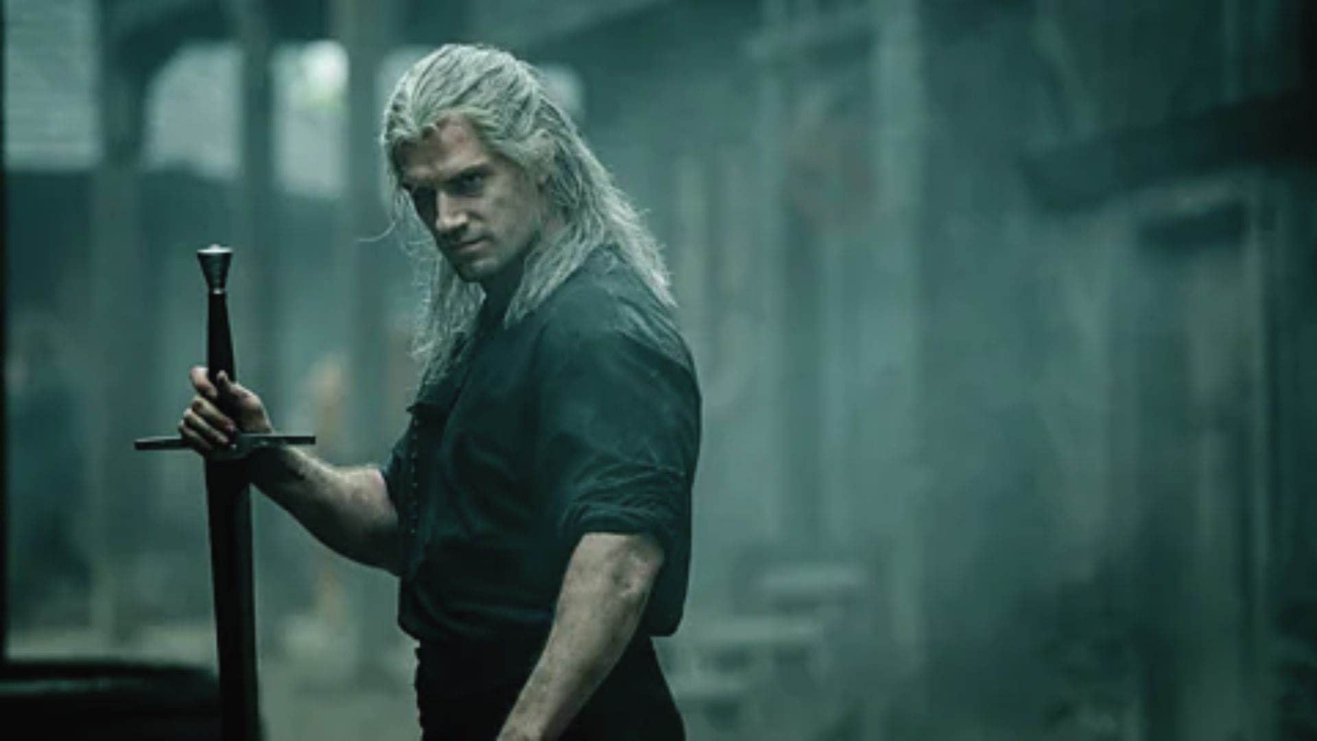Henry Cavill as a witch holding a sword, dressed in a long layered style reminiscent of Geralt of Rivia, stands confidently.