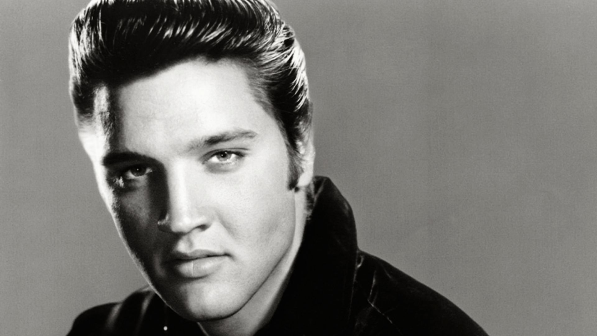 Black and white photo of Elvis Presley showcasing his iconic Pompadour hairstyle.
