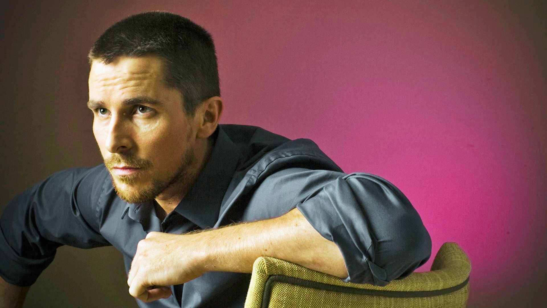 Christian Bale with a short hairstyle, showcasing his iconic dark costume and distinctive hairstyle.
