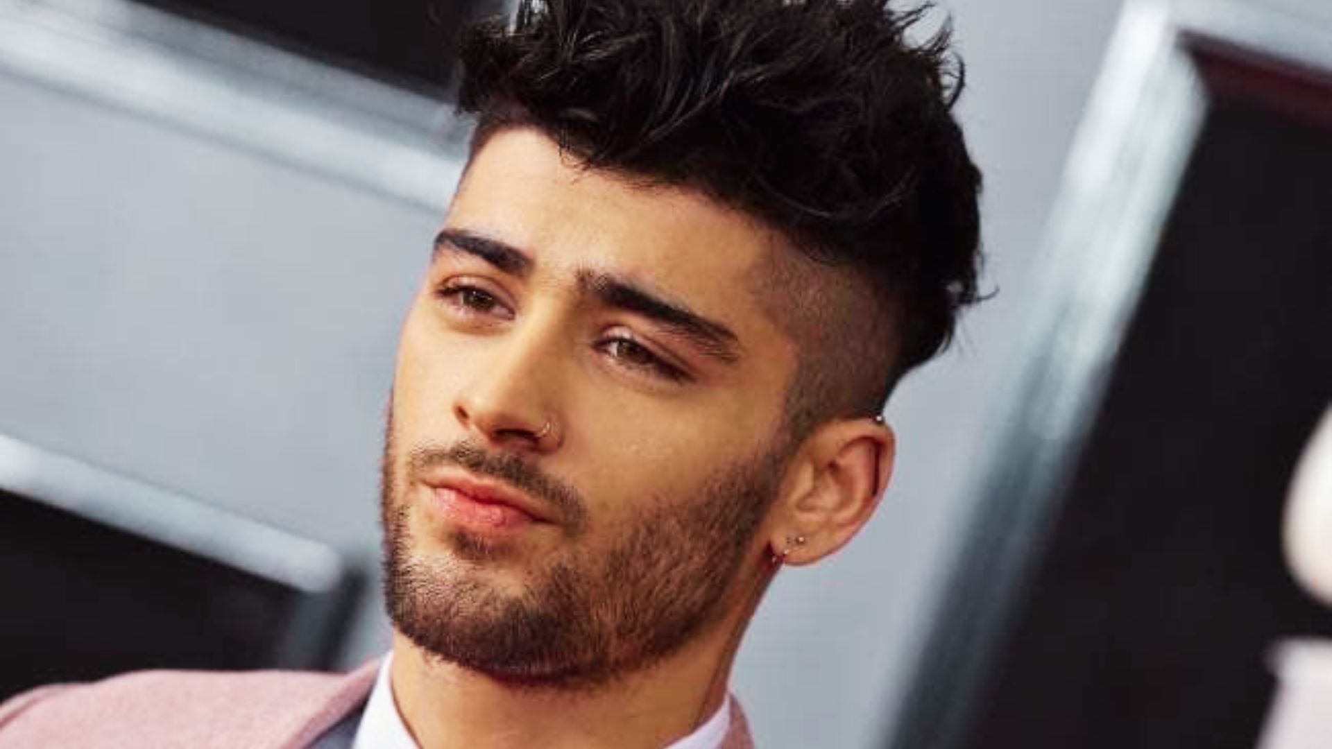 Zayn Malik, a bearded man in a suit, exemplifies a stylish look for a modern haircut ideas.