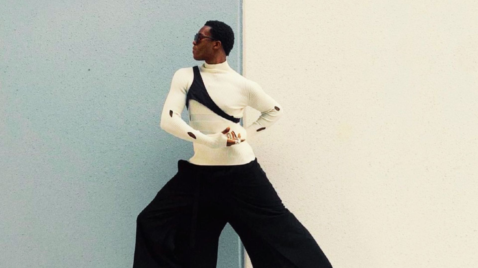 Wisdom Kaye wearing a white sweater and black pants, showcasing a monochrome power outfit for style ideas.