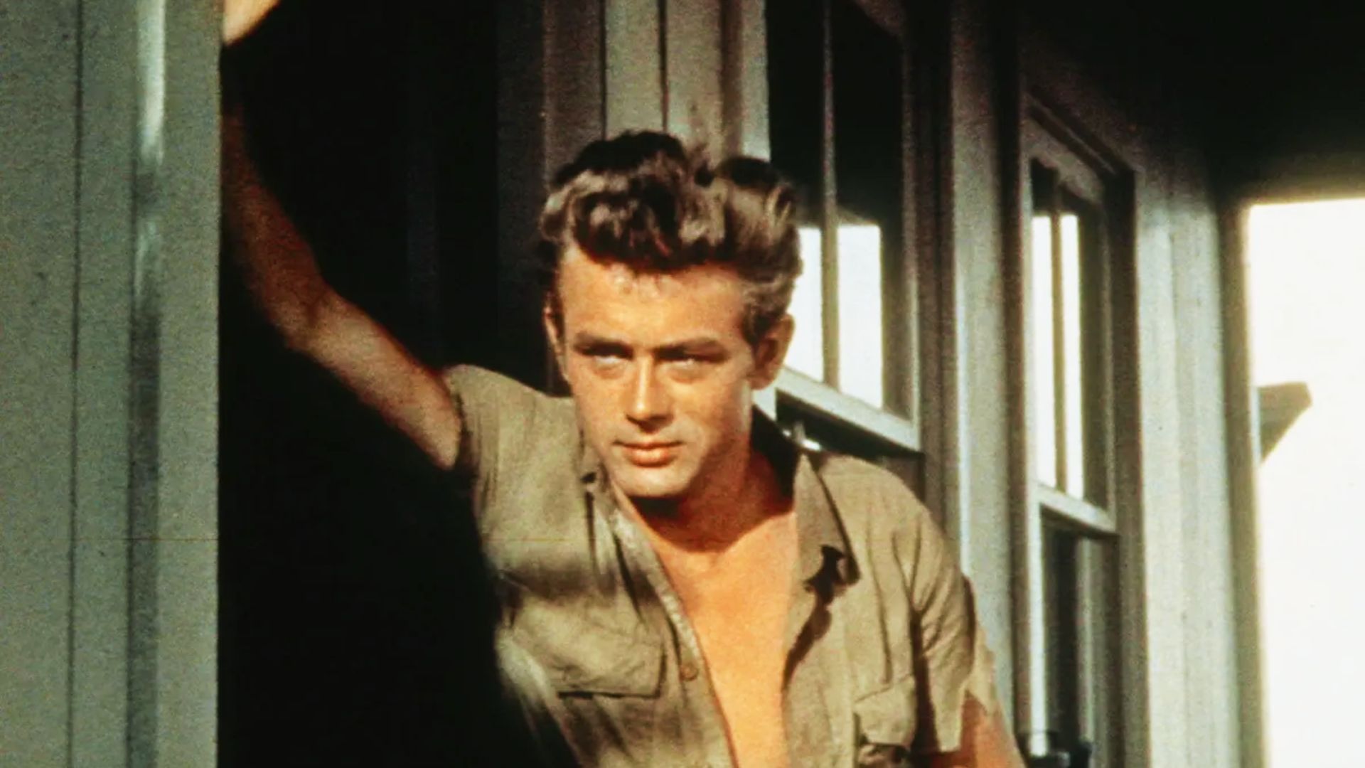 James Dean with wavy hair, posing in a wild berry setting, showcasing hairstyle