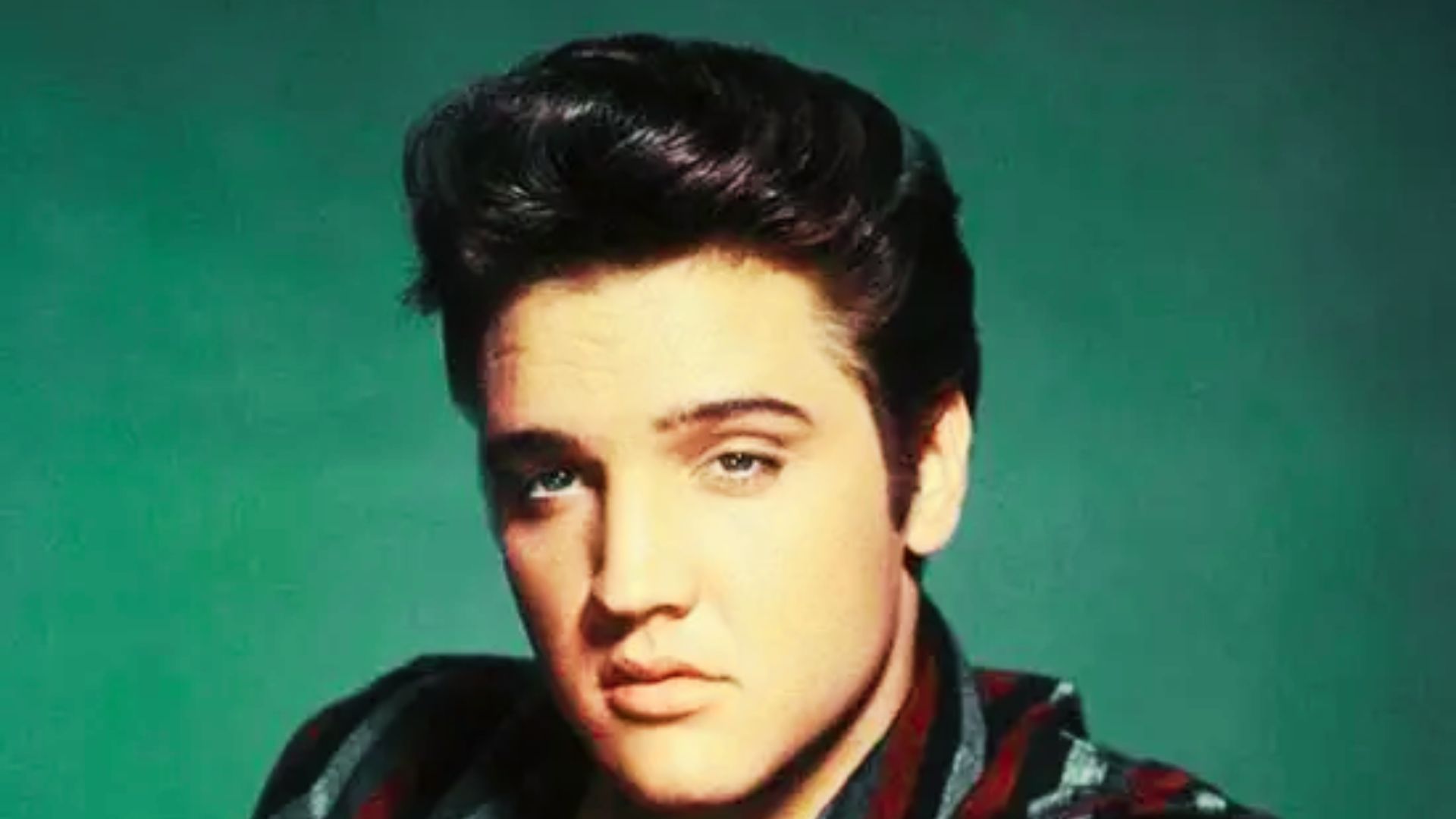 Photo of Elvis Presley showcasing his early natural hairstyle.