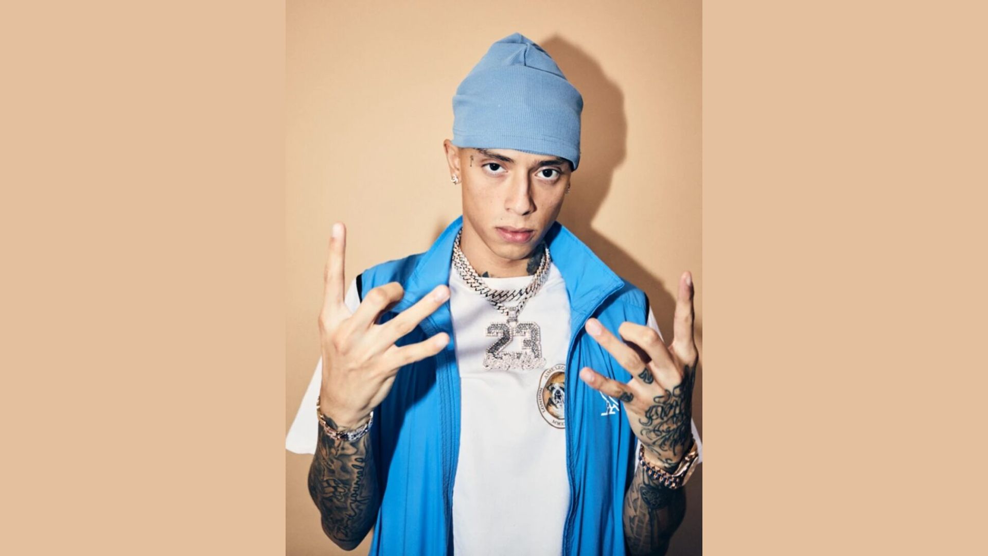 "A man wearing a blue hat with visible tattoos on his arms and neck."